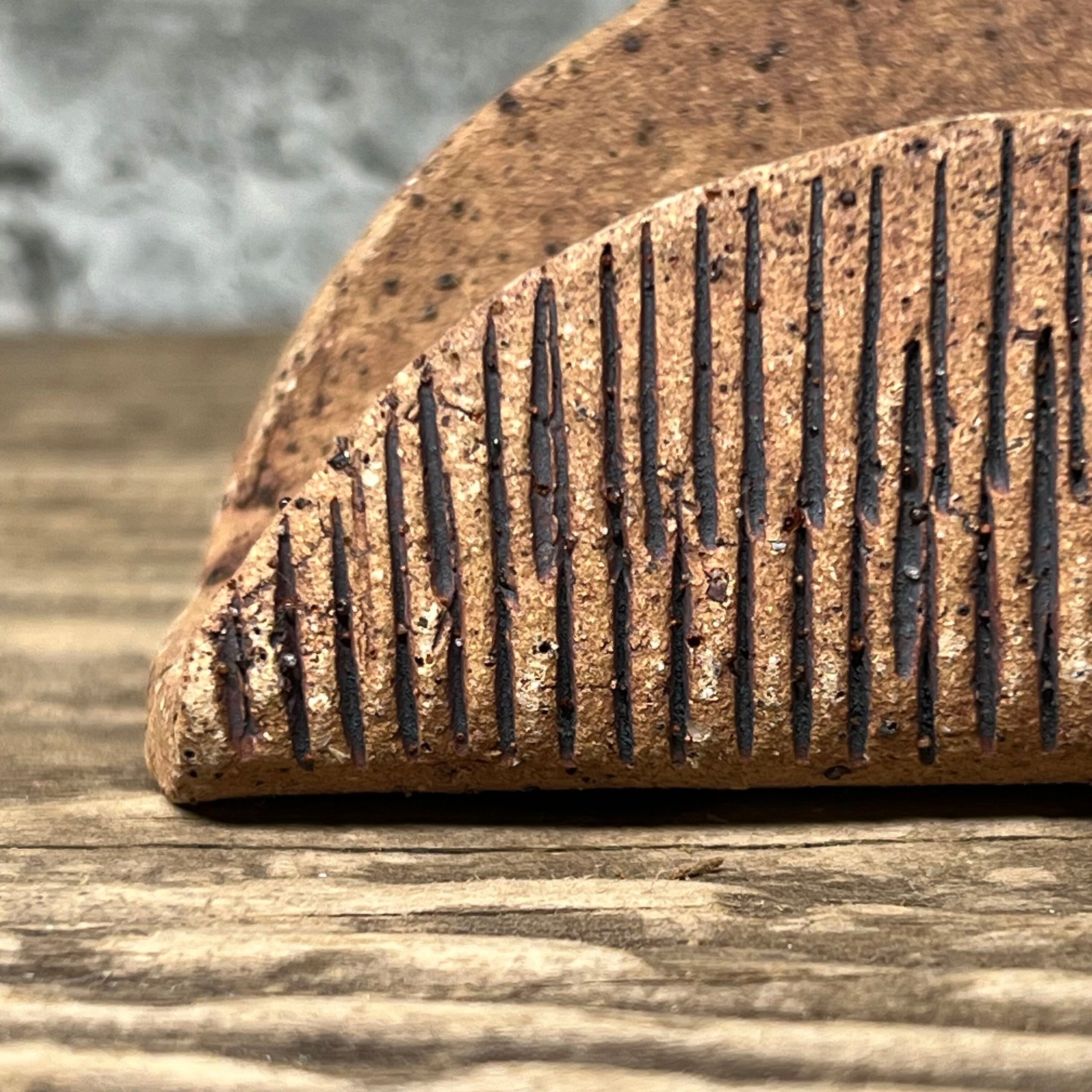 A textured handmade ceramic business card holder with an oxide wash.