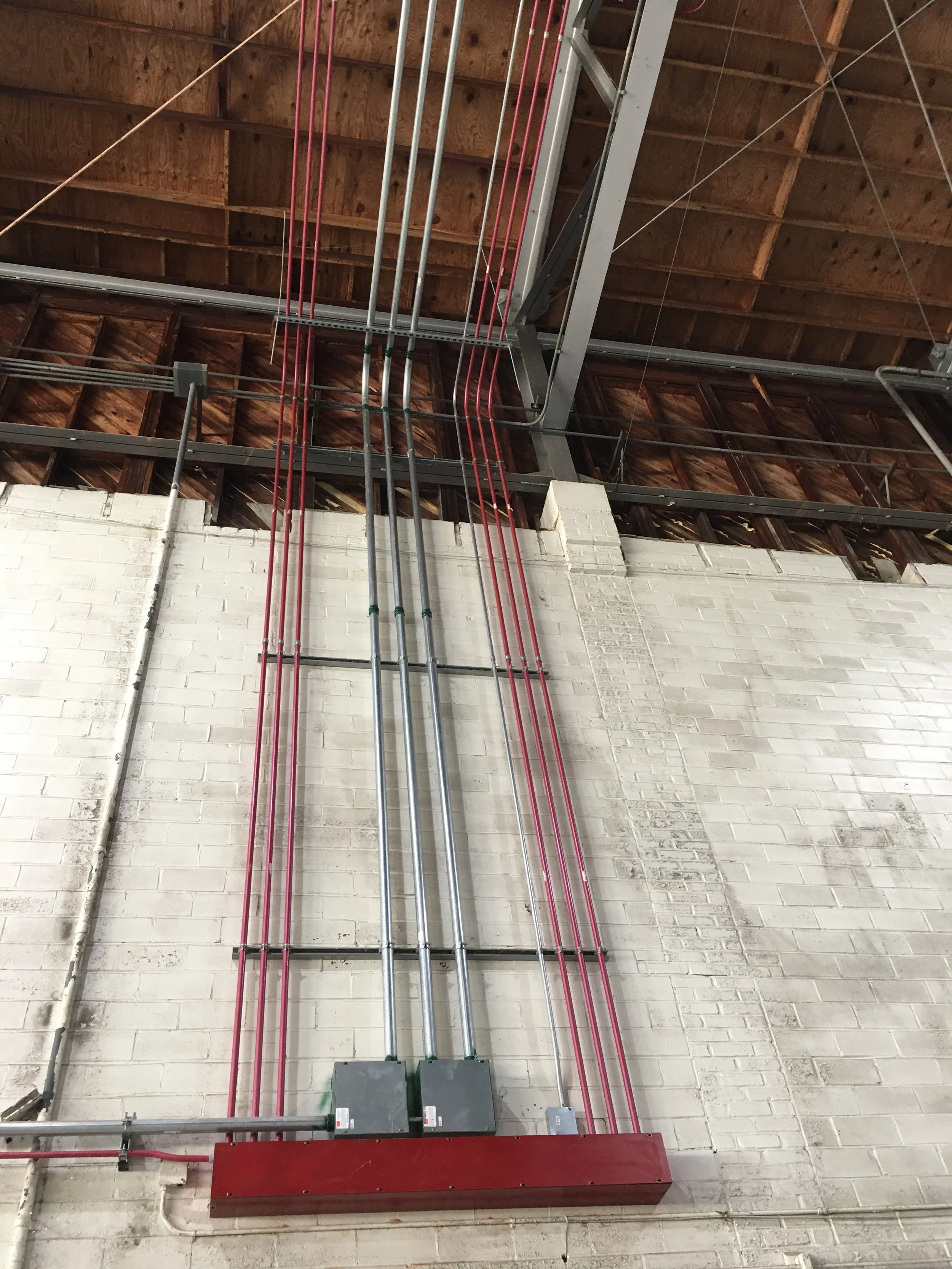 Interior construction site with wooden roof trusses and scaffolding
