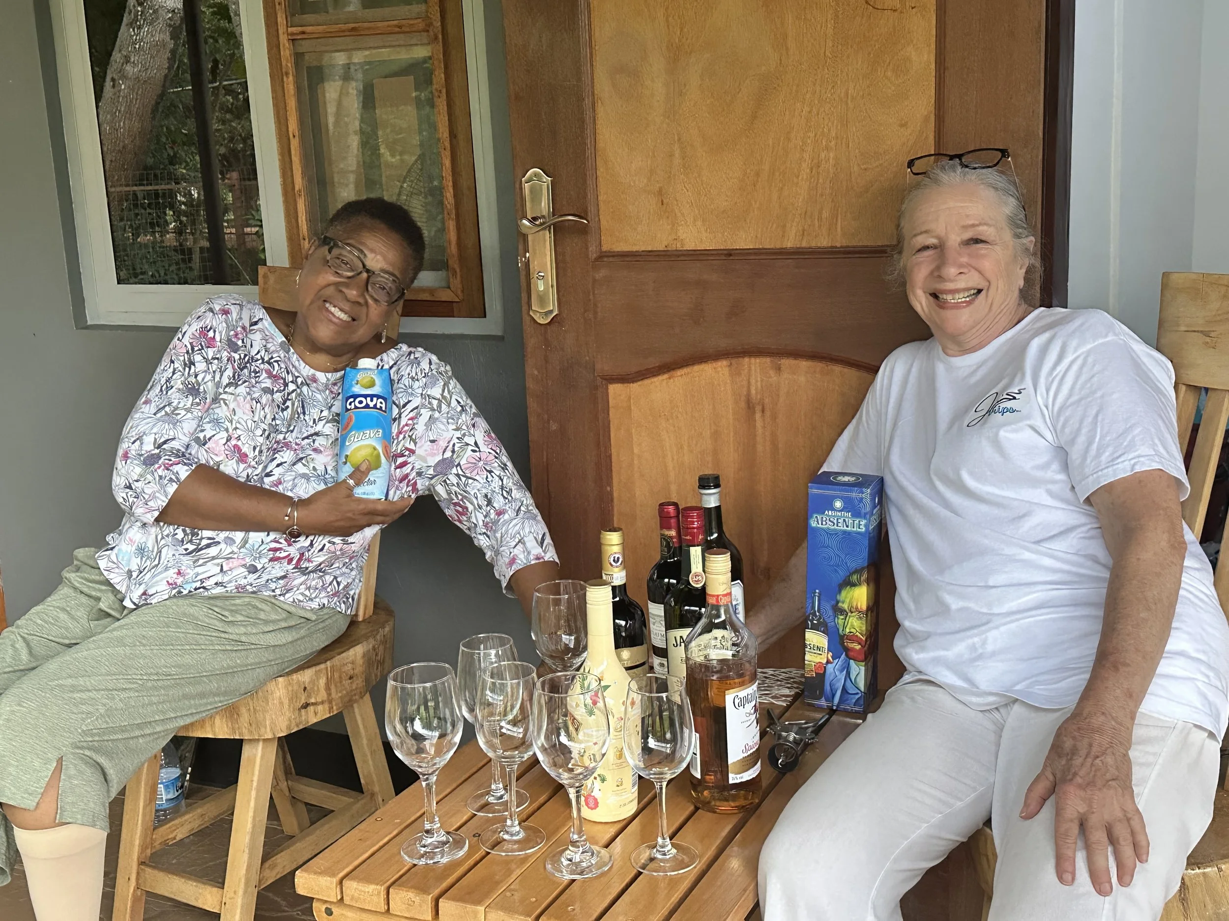 Two participants on our Ugandan Safari Experience enjoying drinks at their accomodation while observing wildlife