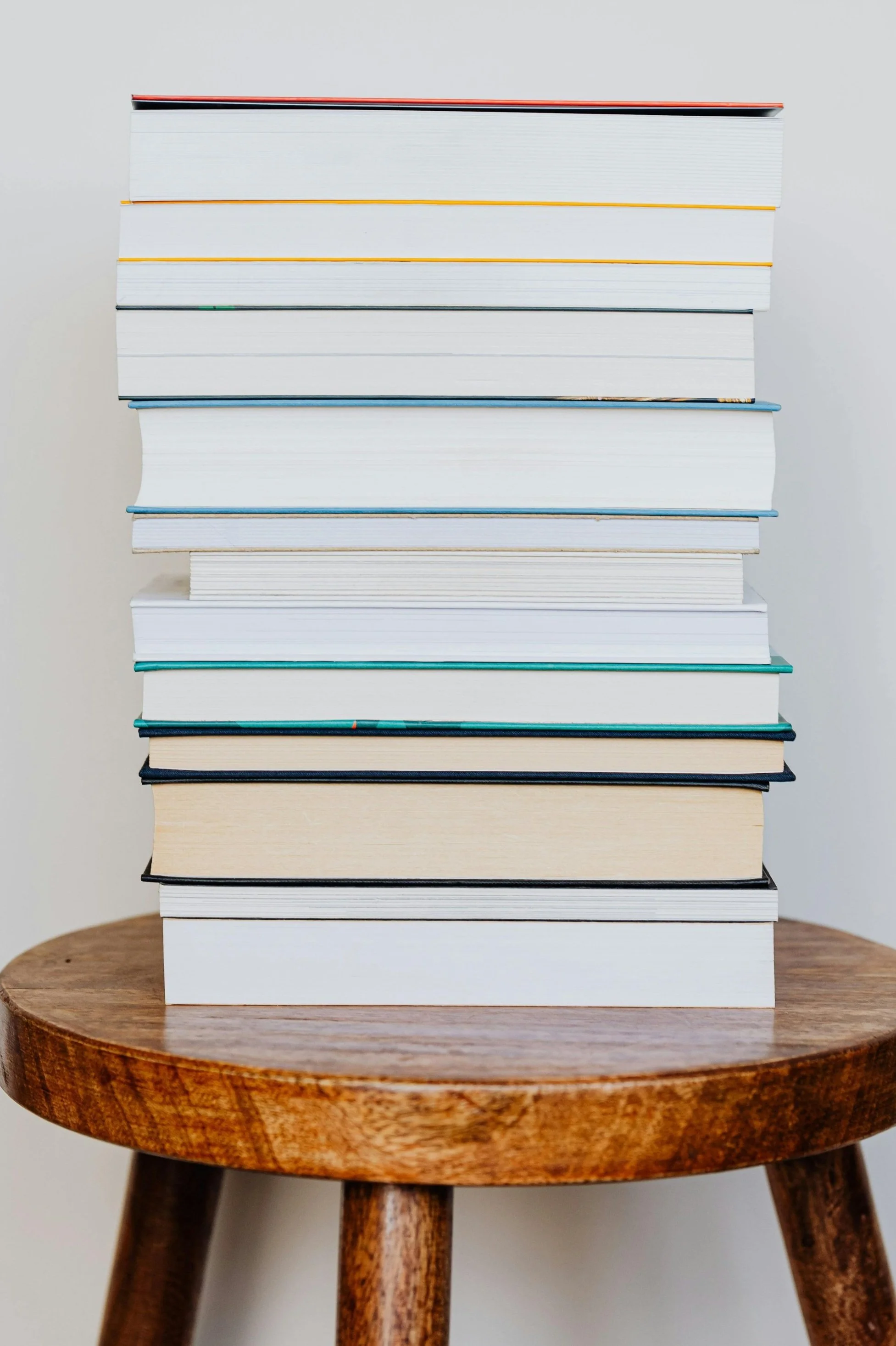 stack of unknown books on  wooden stool.