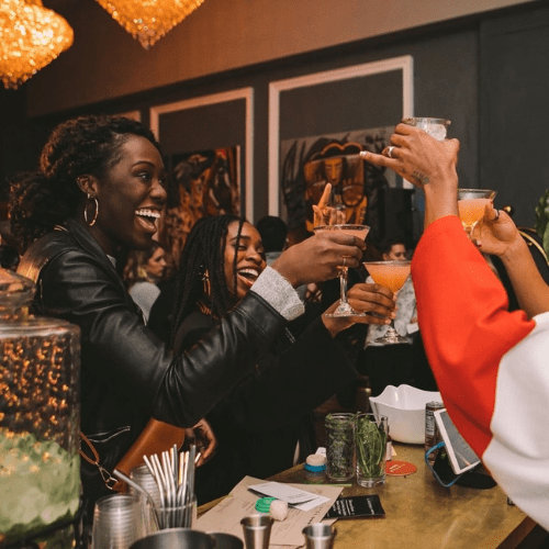 Group of women enjoying drinks and celebrating at a bar or restaurant.