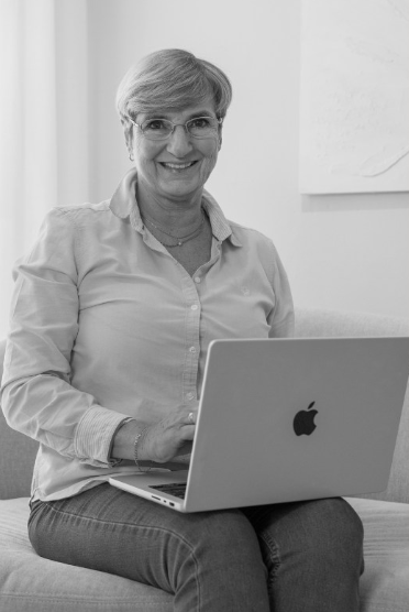 Kund till copywriter sitter på en soffa med en laptop och ler