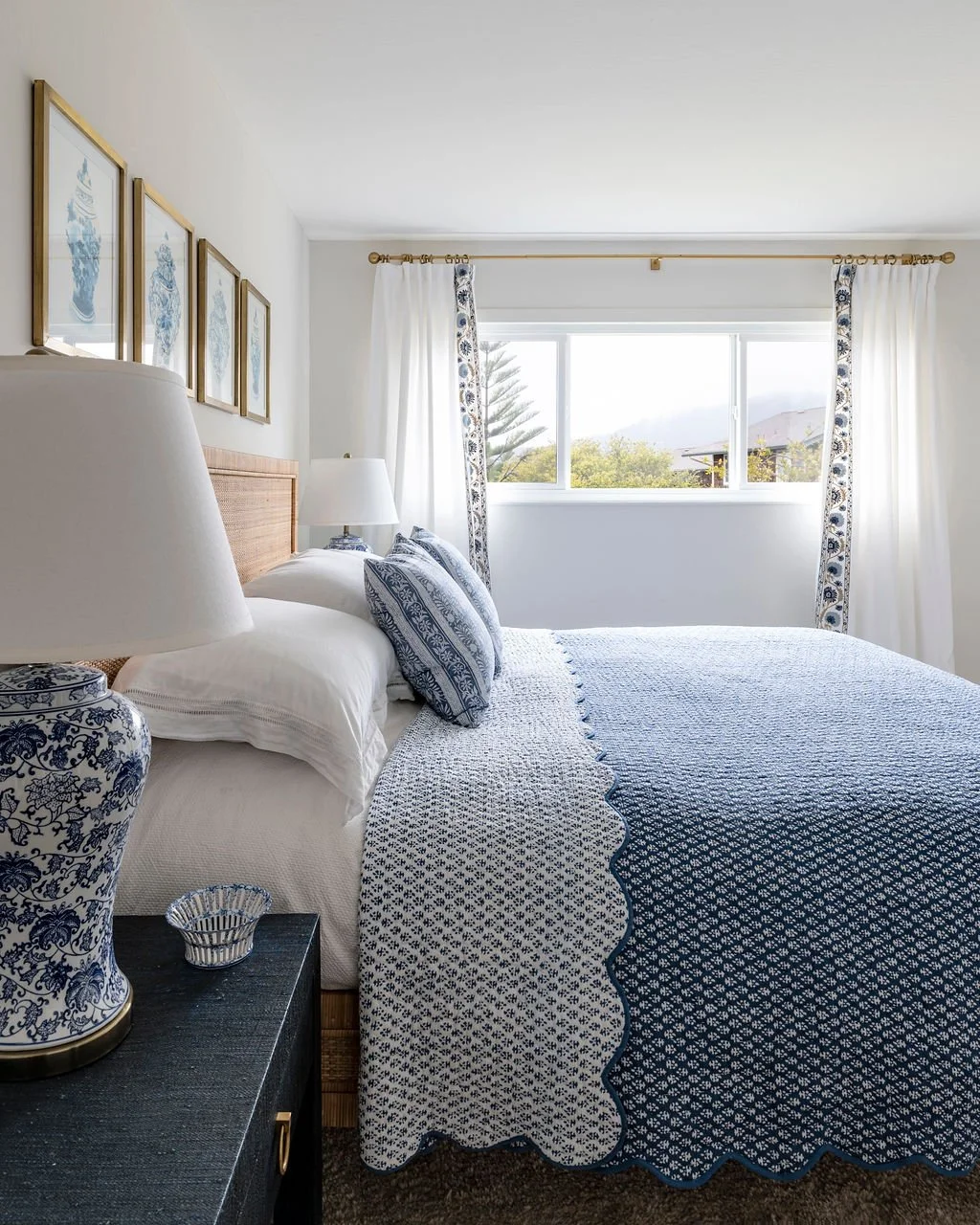 Bedroom styled by Arntz Interiors with blue and white textiles, classic ceramic lamps, and crisp layered bedding.
