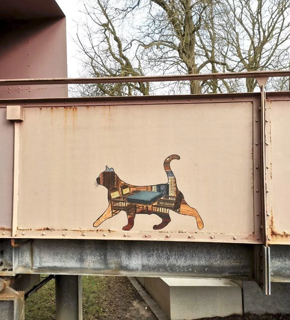 Streetart-Katze am Museumsberg in Flensburg. In der Silhouette ist das Pariser Zimmer aus dem Hans-Christansen-Haus.