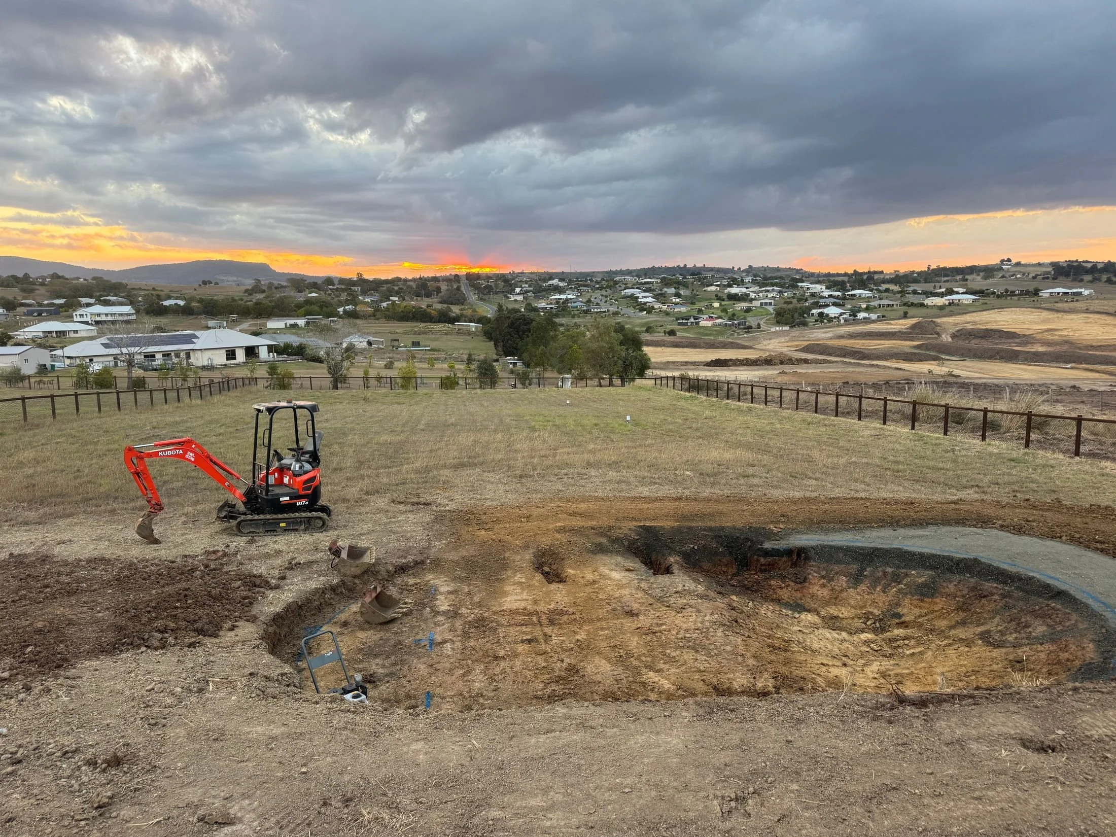 Excavator on an earthworks site at sunset