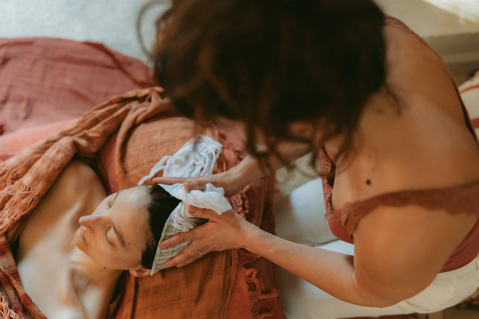 Une femme offre un soin rebozo relaxant a une personne ainsi qu'un massage cranien