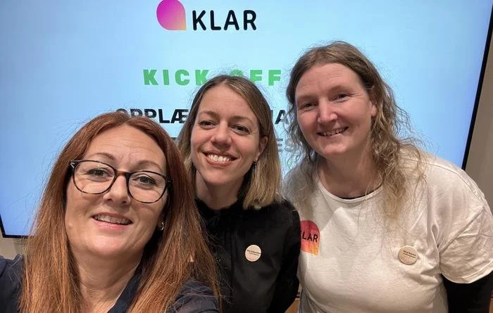 Selfie med 3 damer og presentasjon i bakgrunnen.