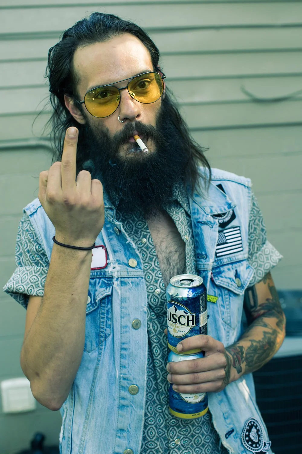 Blue collar bearded guy flipping the bird to the camera of Chad Crawford