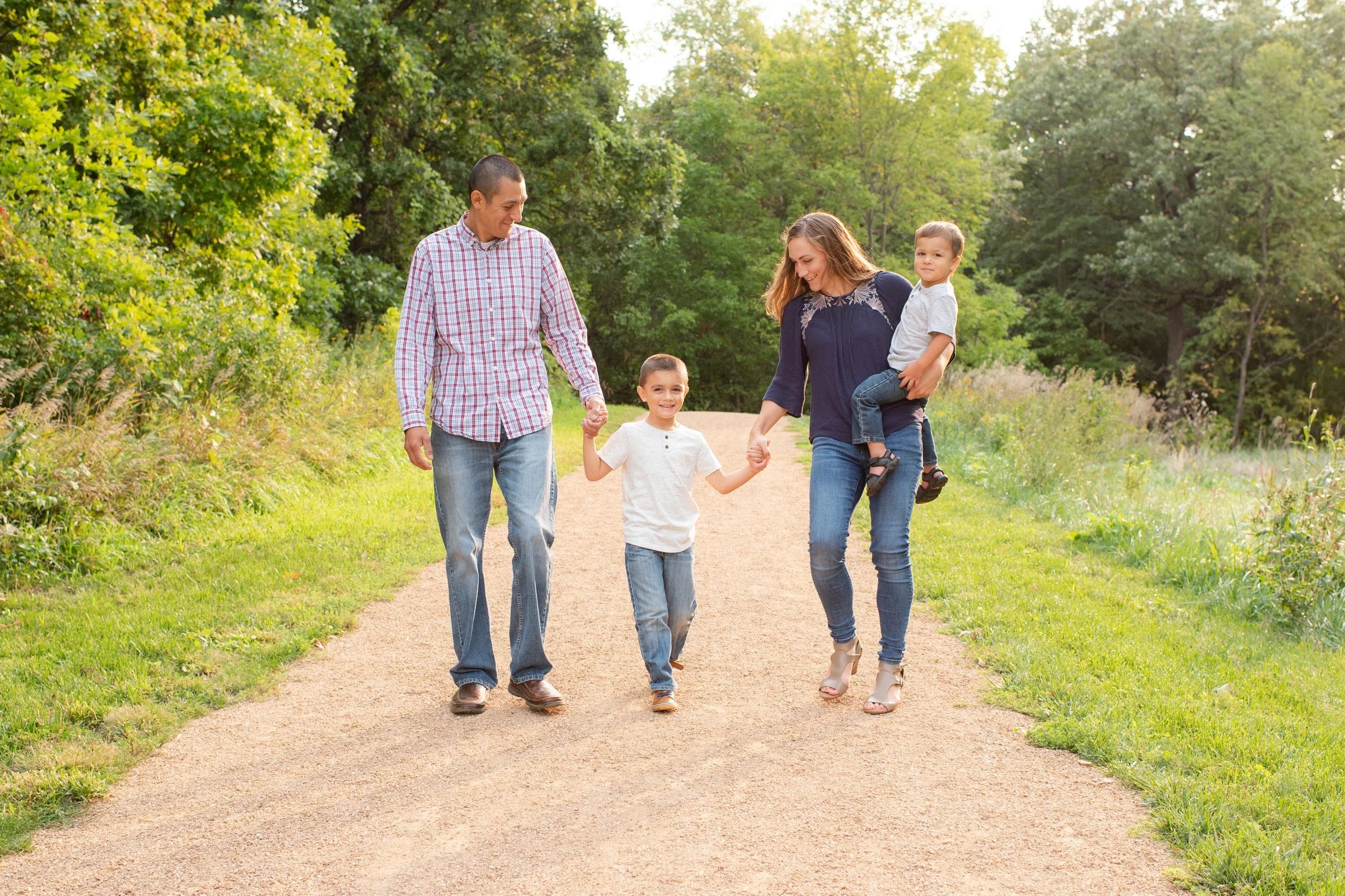 family with young kids walking down a dirt path at Lowry Nature Center in Victoria, MN