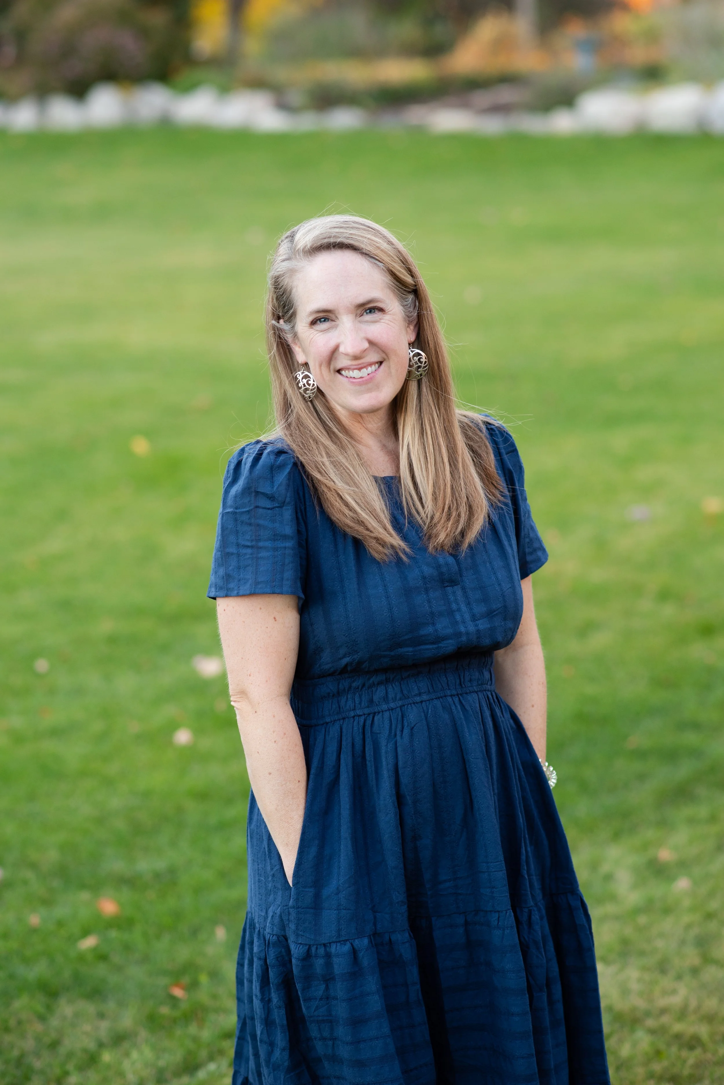 Twin Cities Photographer Jennifer Boyce posing in green grass
