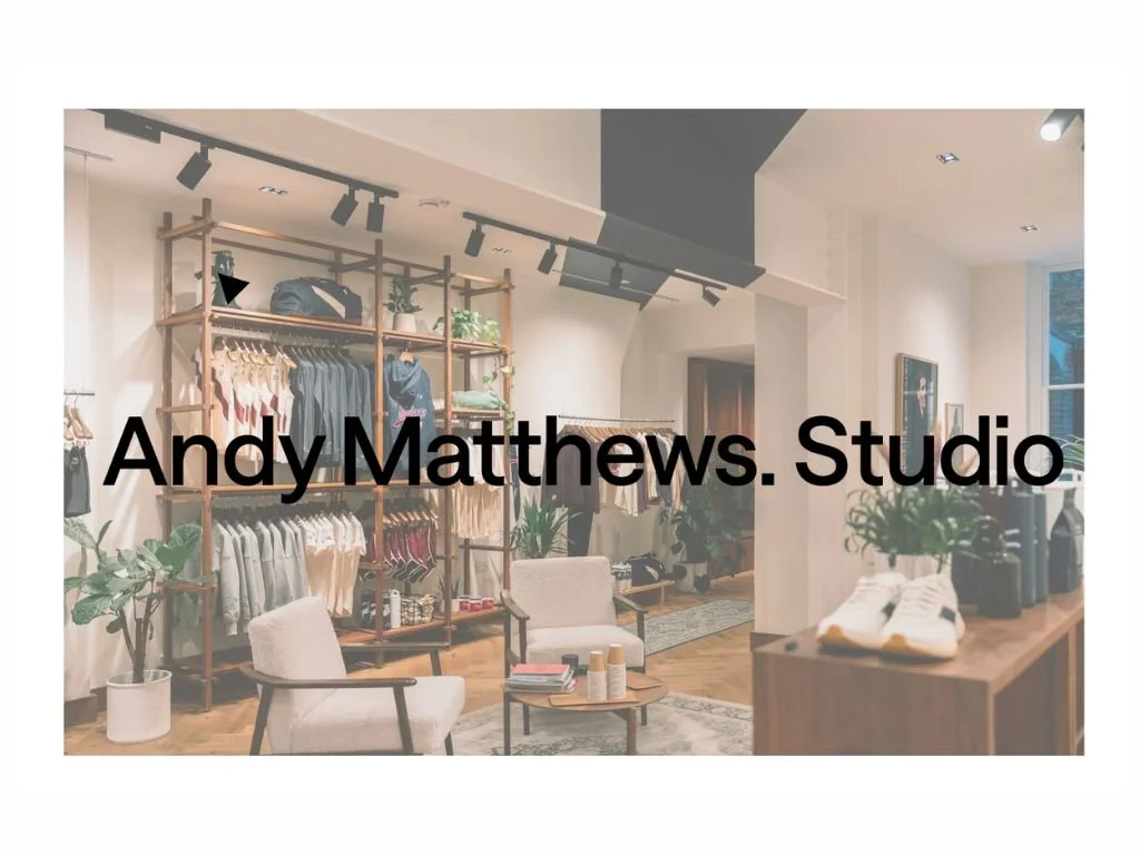 Illustration of a two-story brick house with a small patio, outdoor furniture, and two people inside, surrounded by trees and flowering plants.