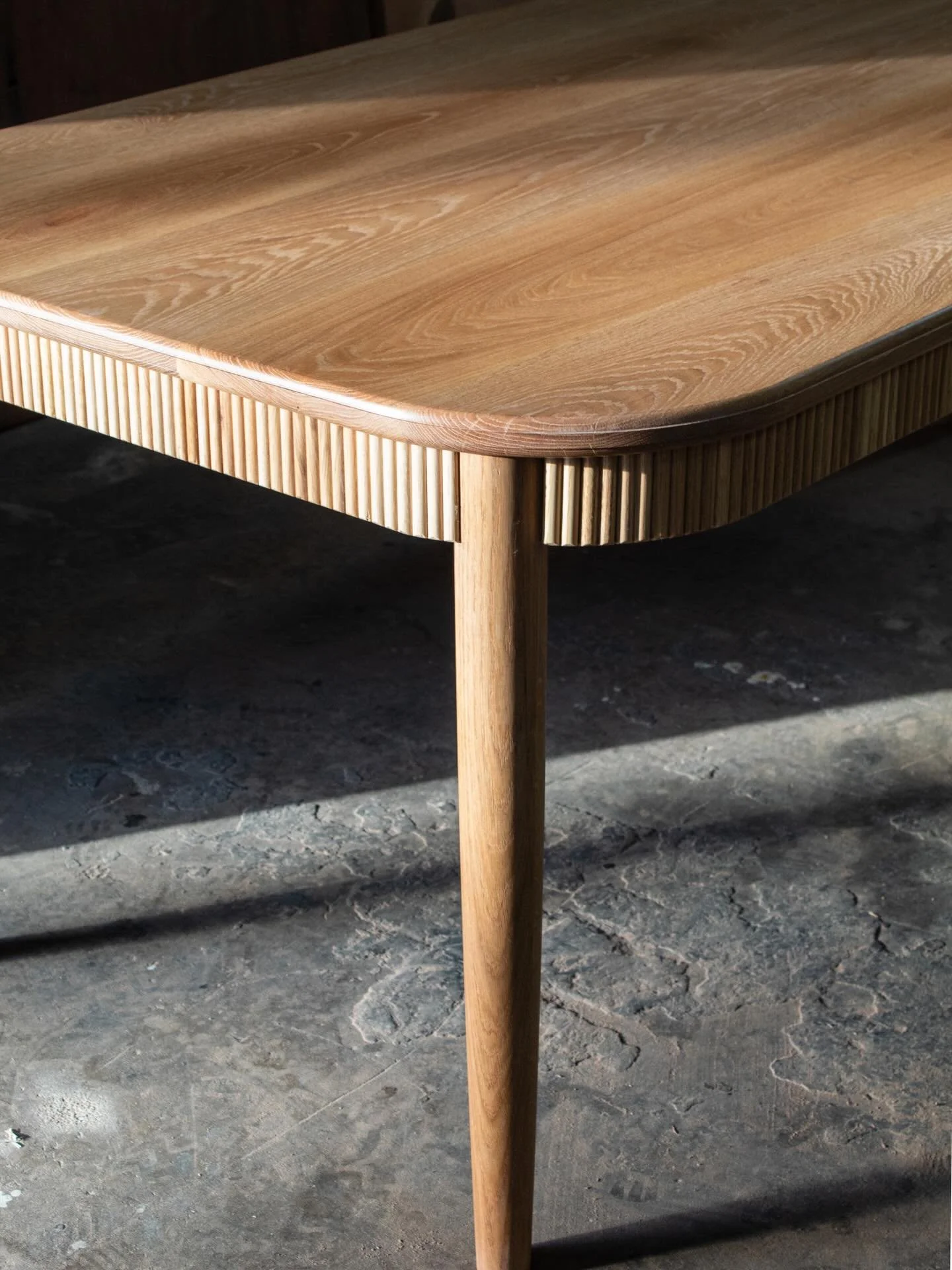 Custom white oak dining table with reeded frame and tapered legs. // 🌳