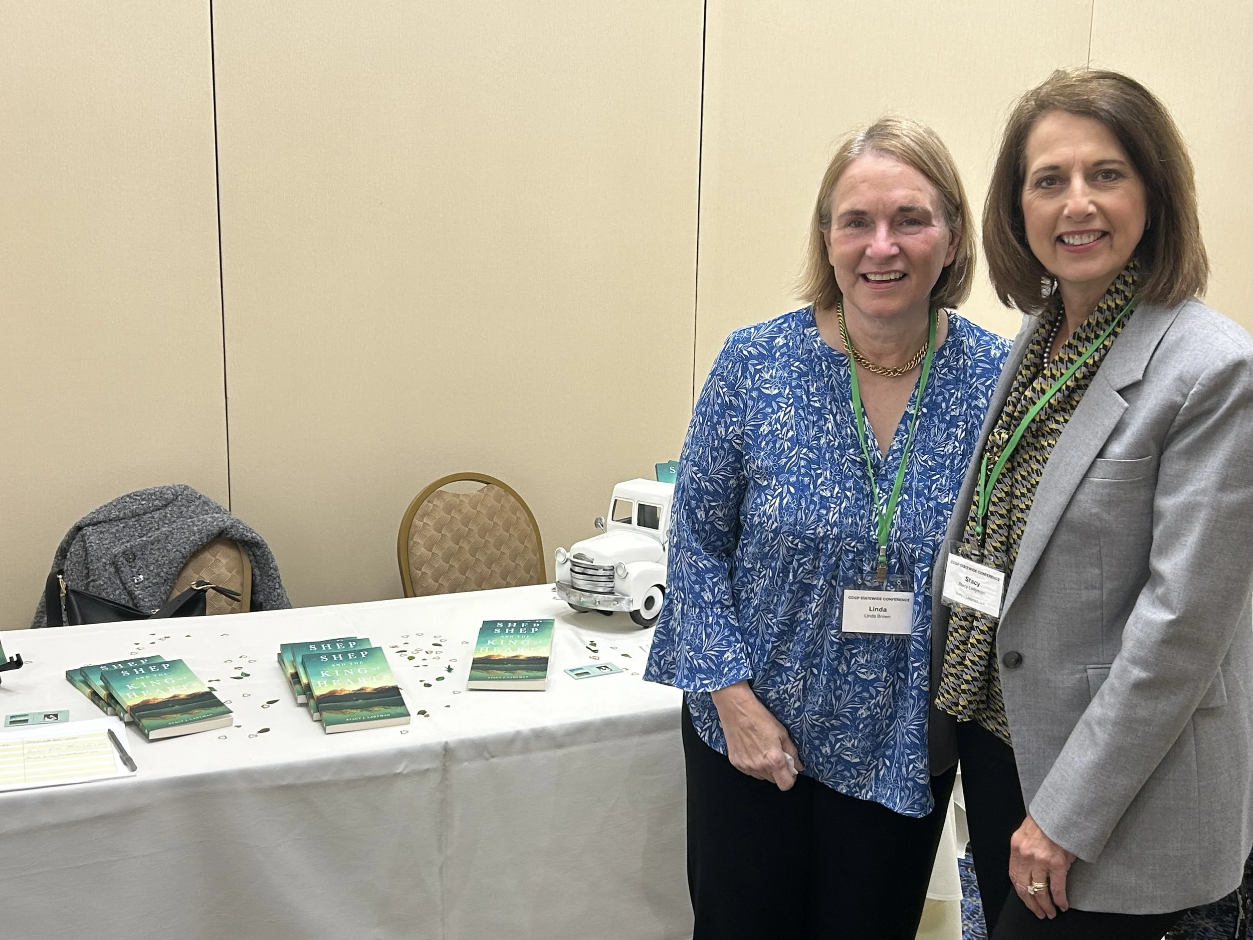 Author Stacy J. Ladyman and woman in blue top at book table at the CCGP Statewide PA Conference