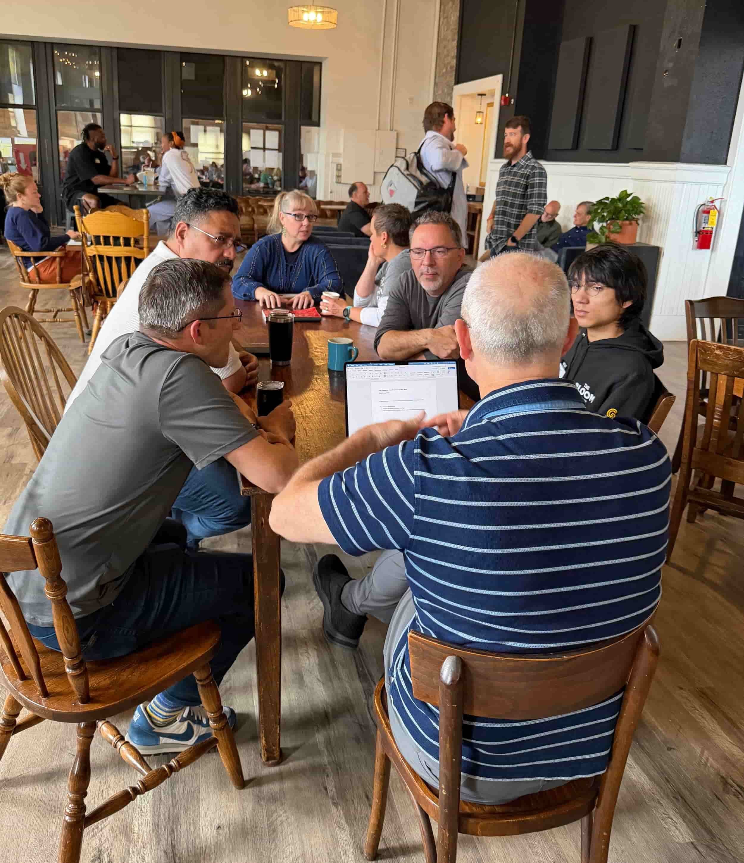 Leaders gather around a table for a small-group discussion on the All Change jounrey..