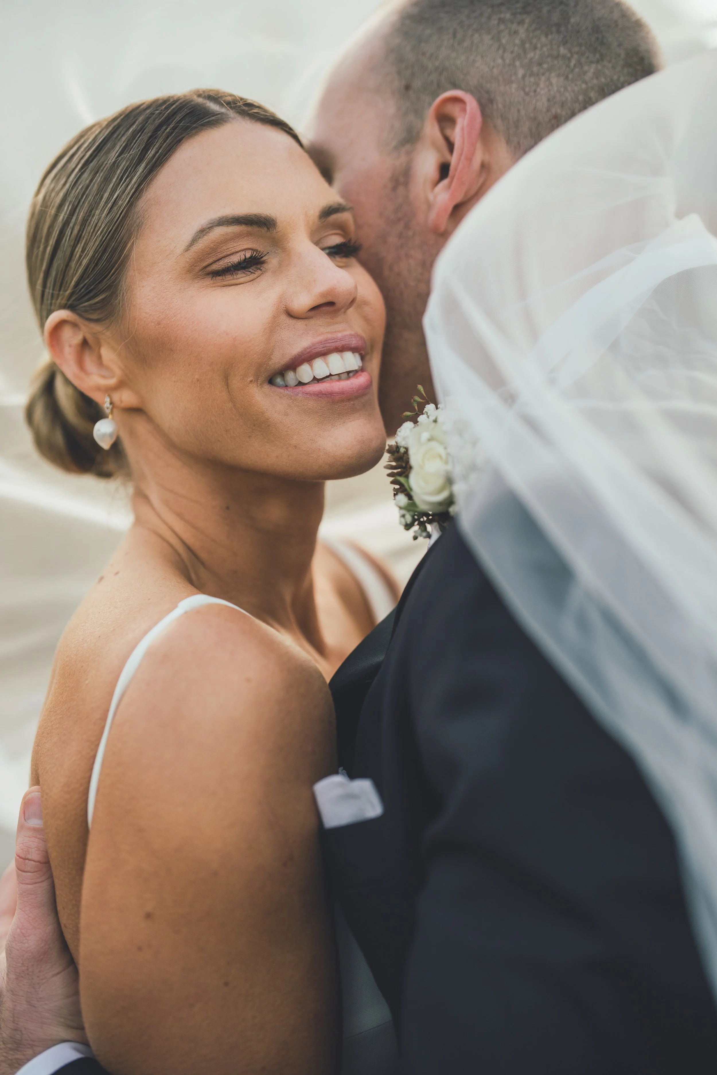 A bride and groom sharing an intimate moment, smiling and close together, during their wedding.