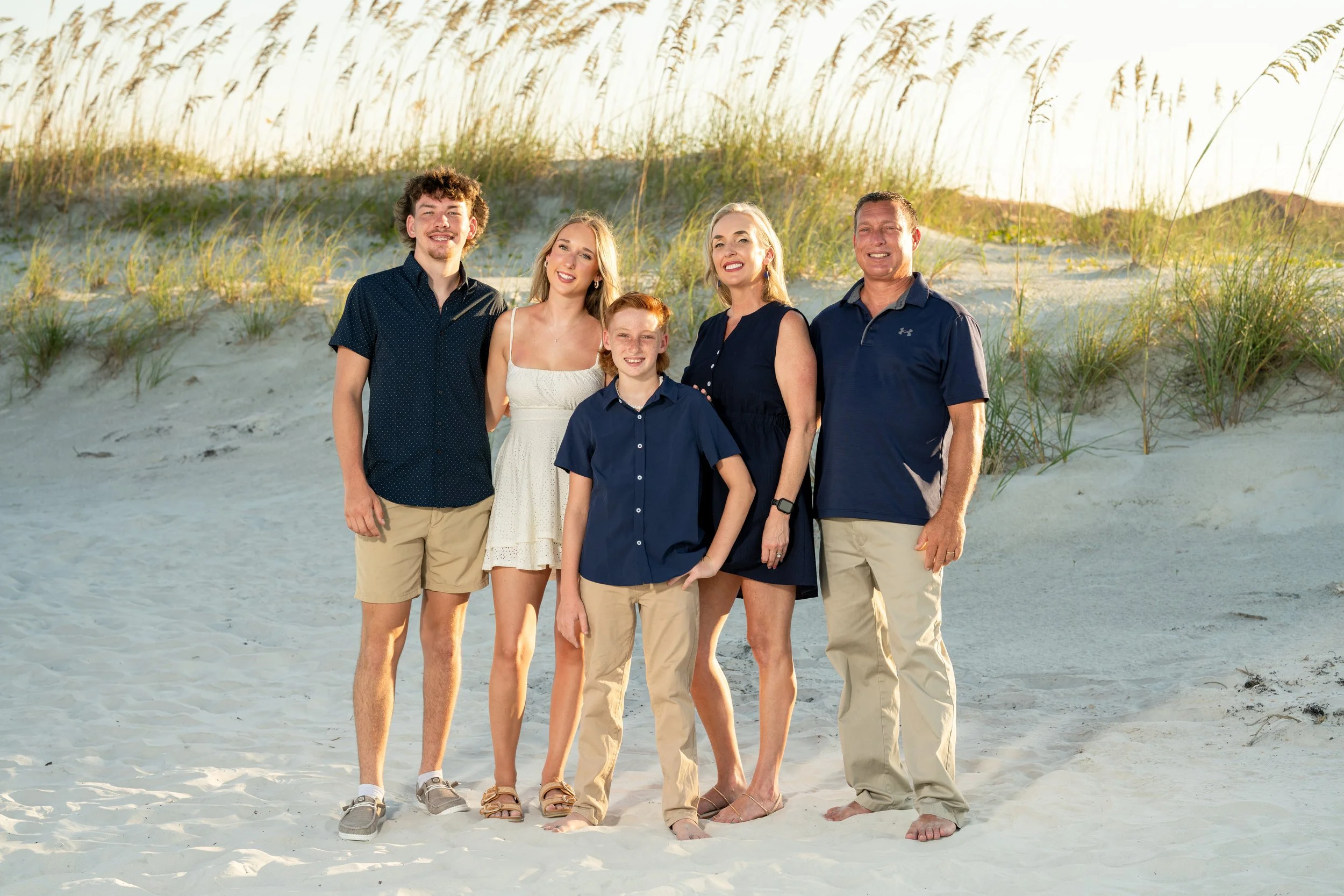 Family photography session on the beach in St. Augustine Beach.   Beautiful sand dune background with sea oats.  Full Family Grouping on a sunny beach day.  