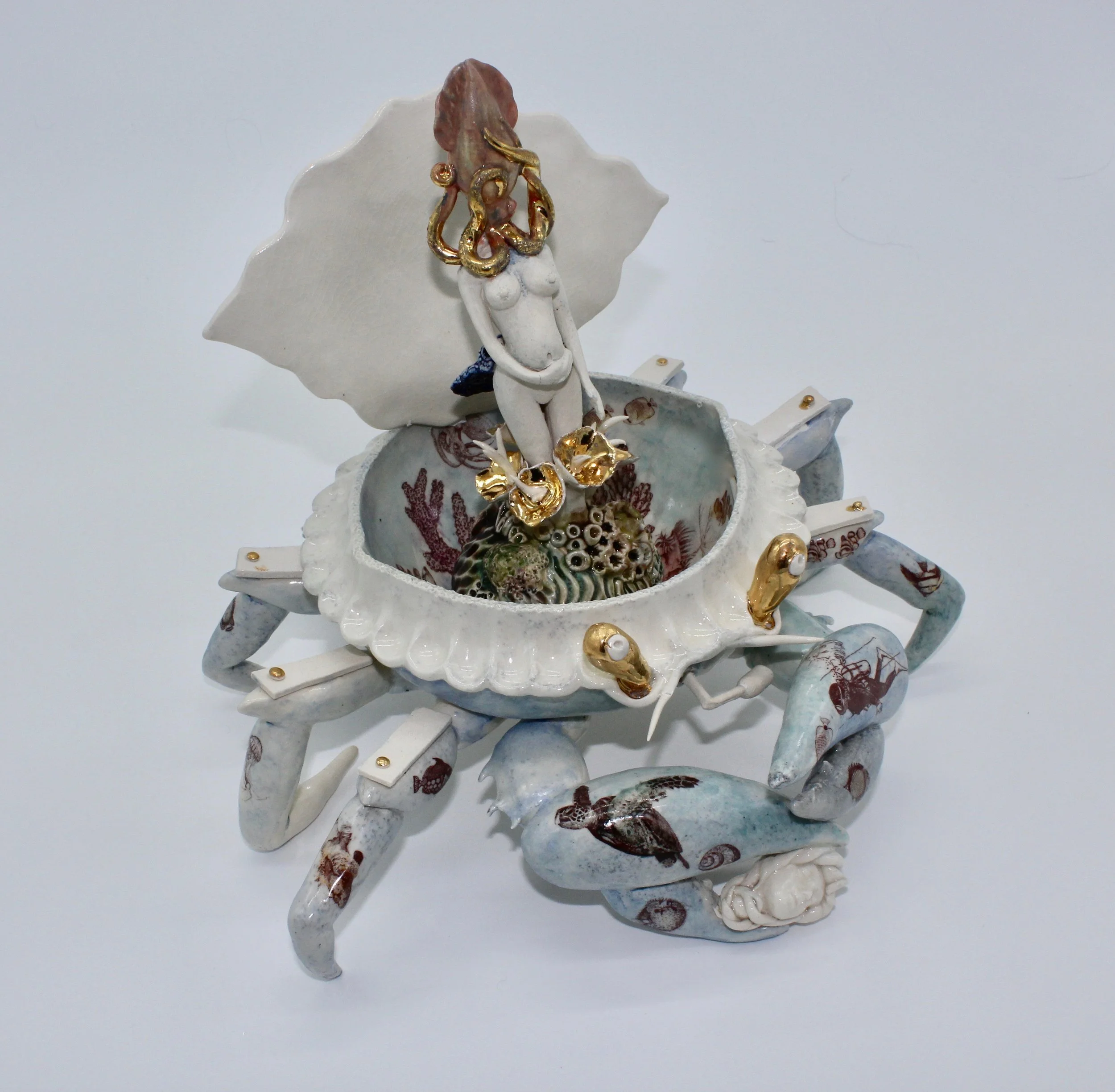 “Let Your Nightmares Lull You to Sleep” is a haunting ceramic sculpture—a paradoxical blend of comfort and disquiet.  The music box, crafted in the form of a crab, beckons with its open, hinged shell. Crabs, ancient creatures of the sea, evoke both p