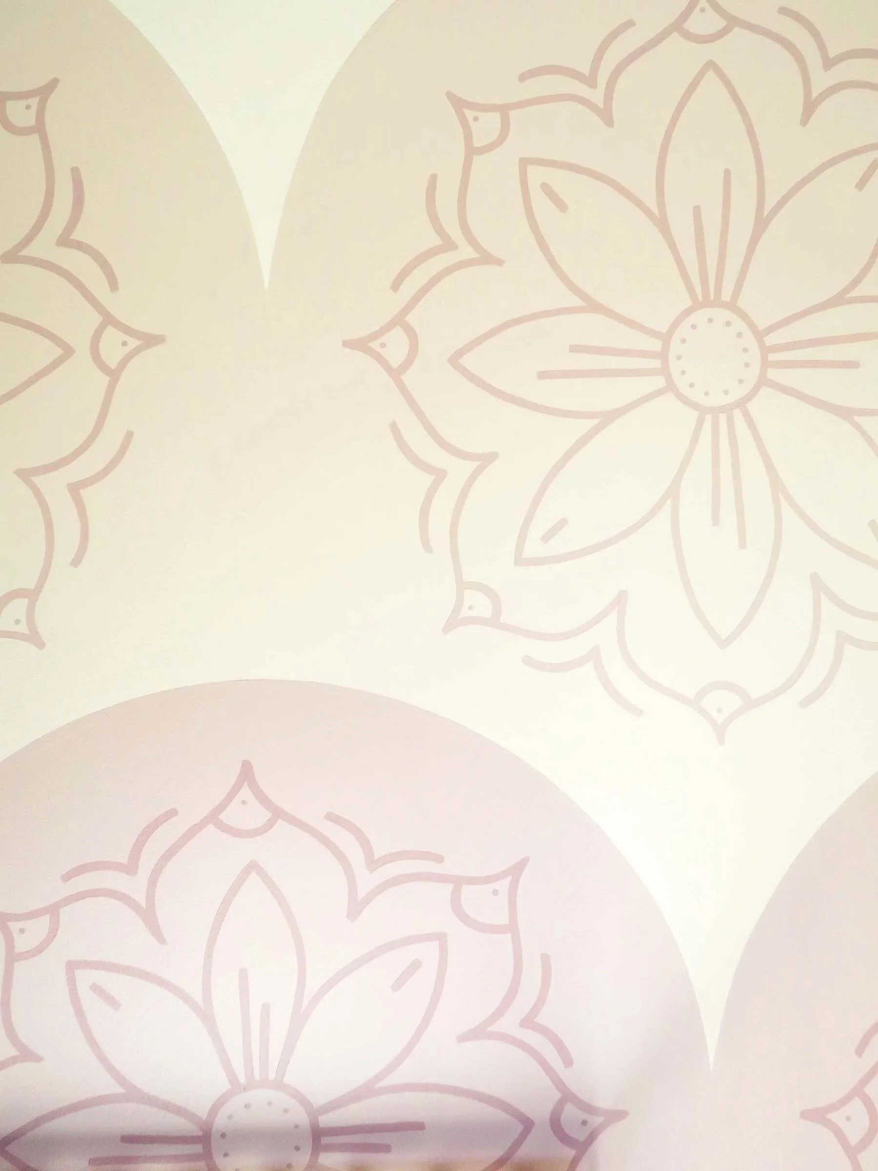 A hand painted mural of large, stylized flowers with petals and a circular center, outlined in light pink on a white background. SF Bay Area mural artist interior design portfolio & inspiration.