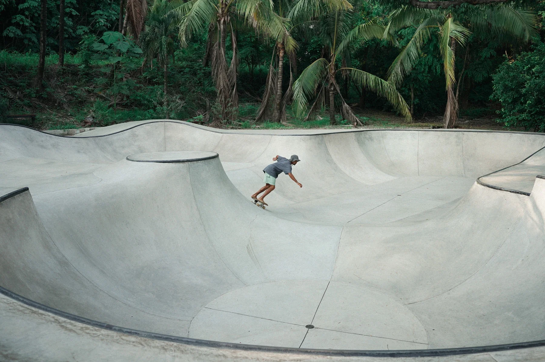 A person skateboarding in a concrete skate park surrounded by tropical trees Guiones, Costa Rica
