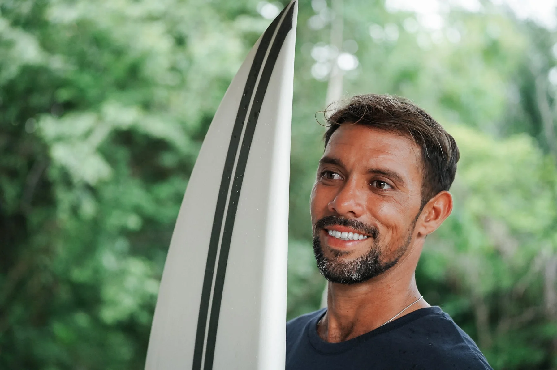 ISA-certified surf coach in Nosara, Costa Rica smiling holding a surfboard