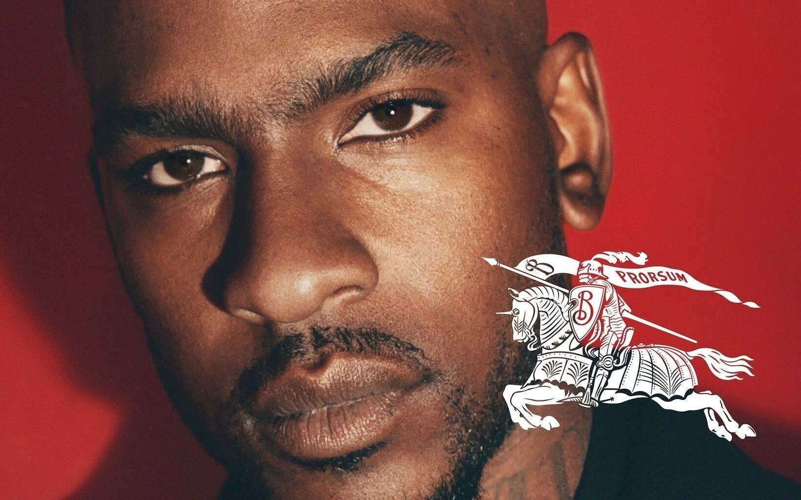 Close-up of a man's face against a red background with a white knight and horse logo.