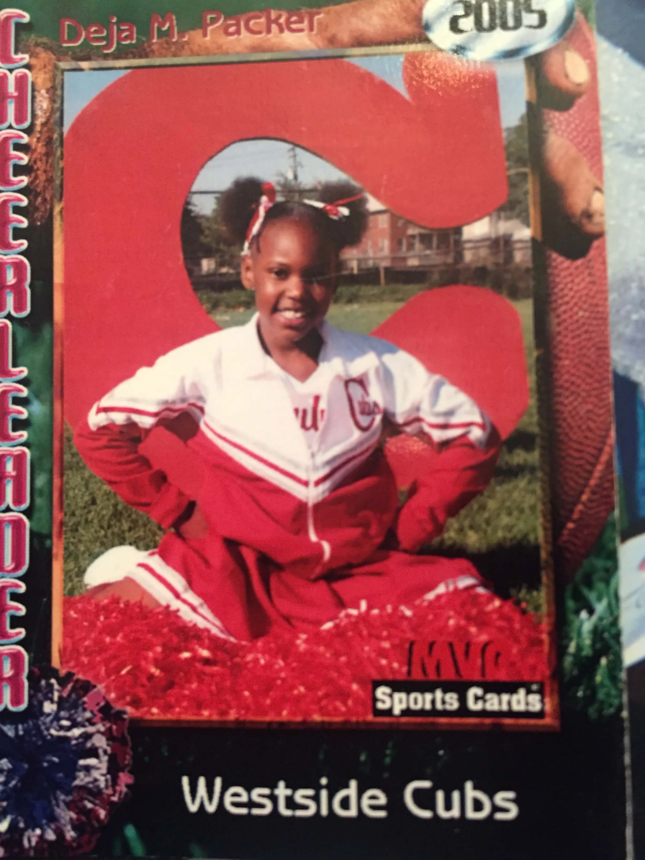 A young cheerleader in a red and white uniform poses on a sports card. The card features the words "Westside Cubs" and is from 2005. The background includes a large red "C" and red and blue pom poms.
