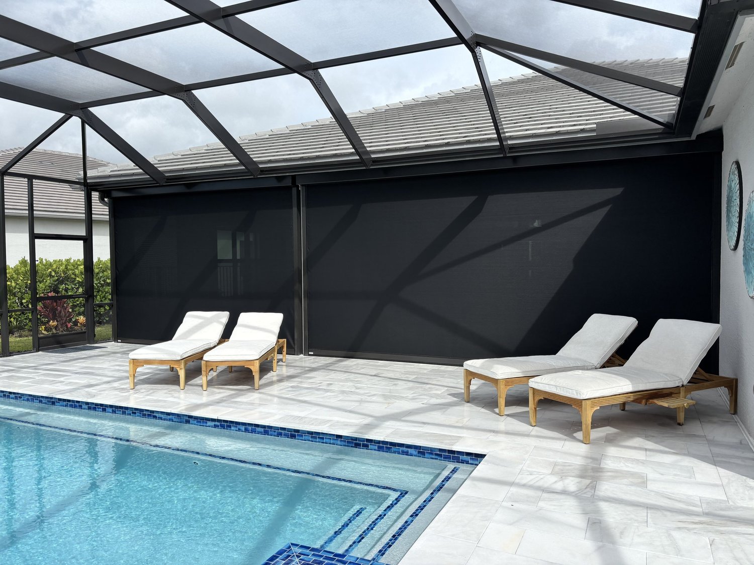Bronze and black UltraShield hurricane screens deployed on a screened pool enclosure, installed by Expert Shutter Services, serving Vero Beach, FL