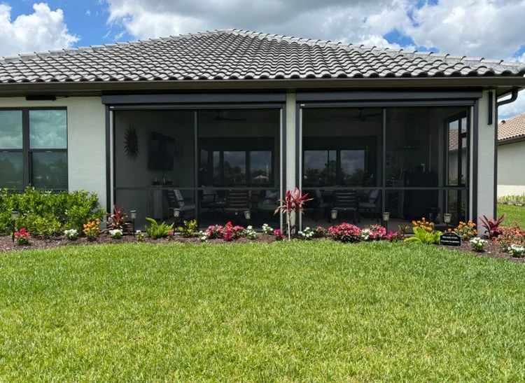 Motorized UltraShield screens partially open on a lanai, installed by Expert Shutter Services, serving Jensen Beach, FL