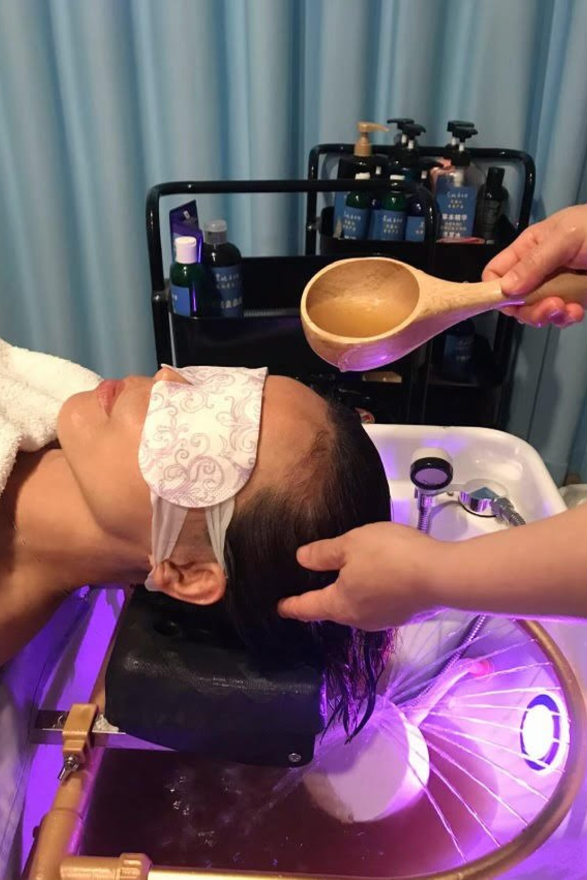Woman receiving an herbal medicine head spa treatment to promote hair growth