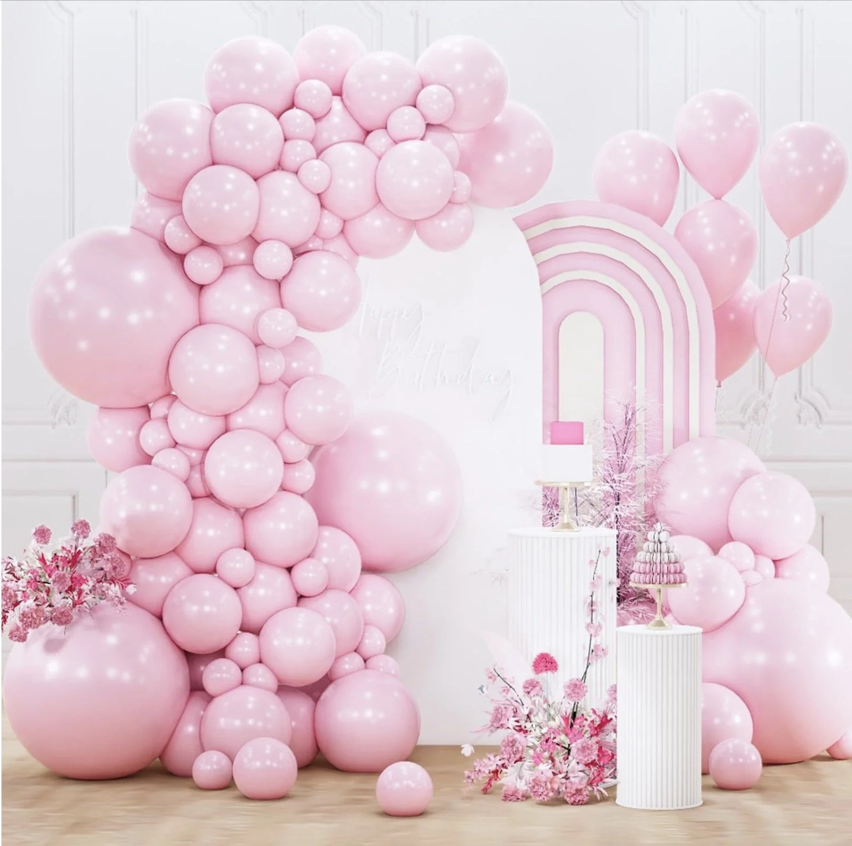 Pink balloon arch backdrop styled for a birthday party with soft pastel balloons and modern décor