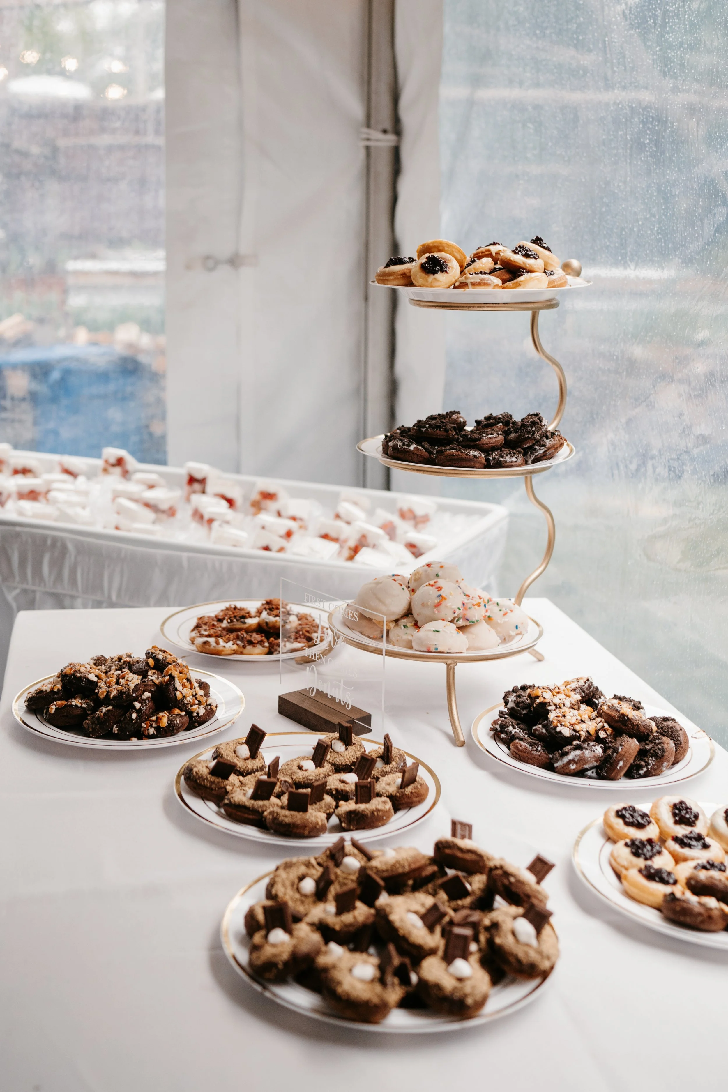 Elegant dessert table with assorted cookies and pastries displayed on tiered stands at a luxury event.