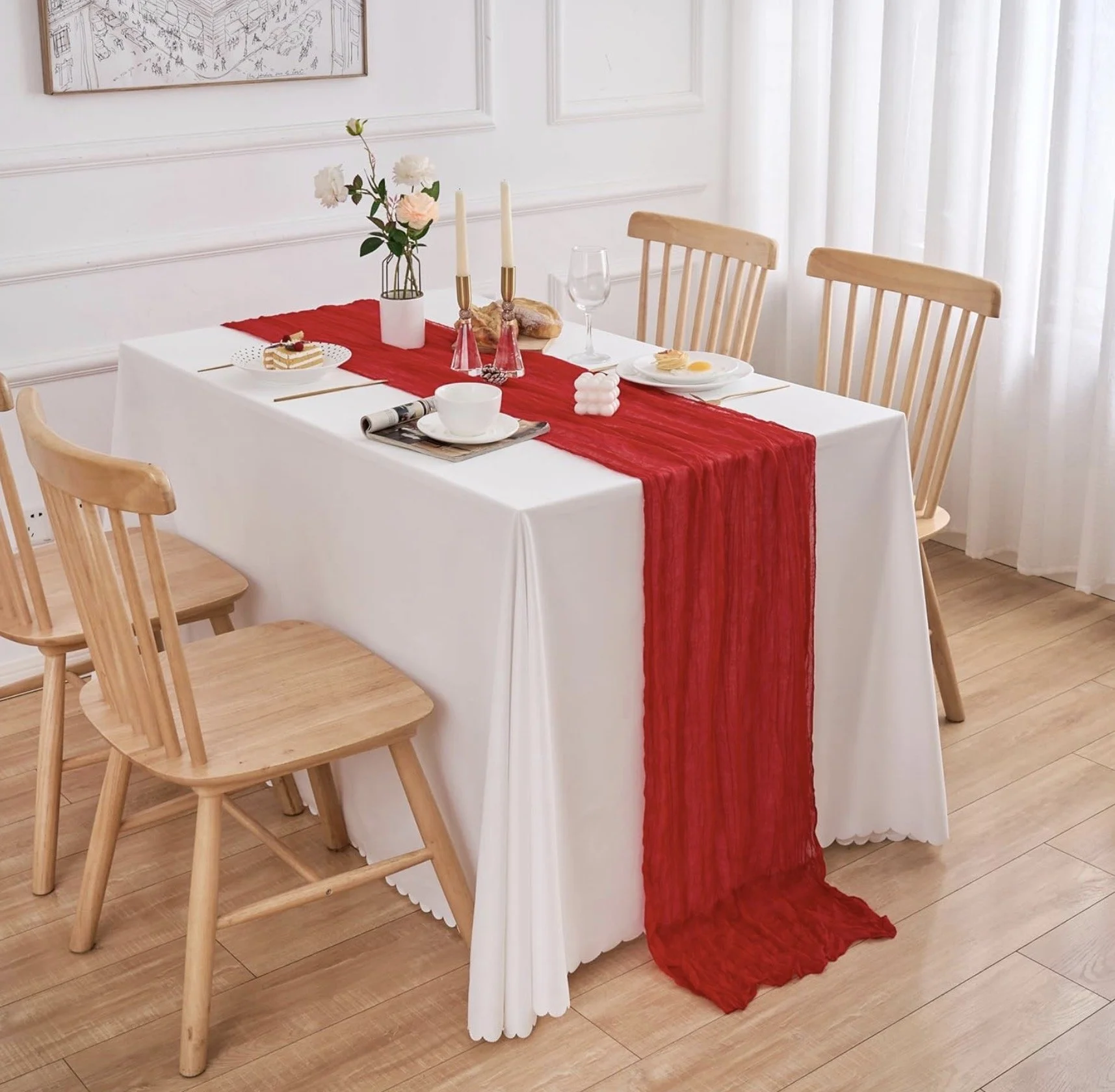 White dining table styled with a red cheesecloth table runner for romantic Valentine’s Day décor