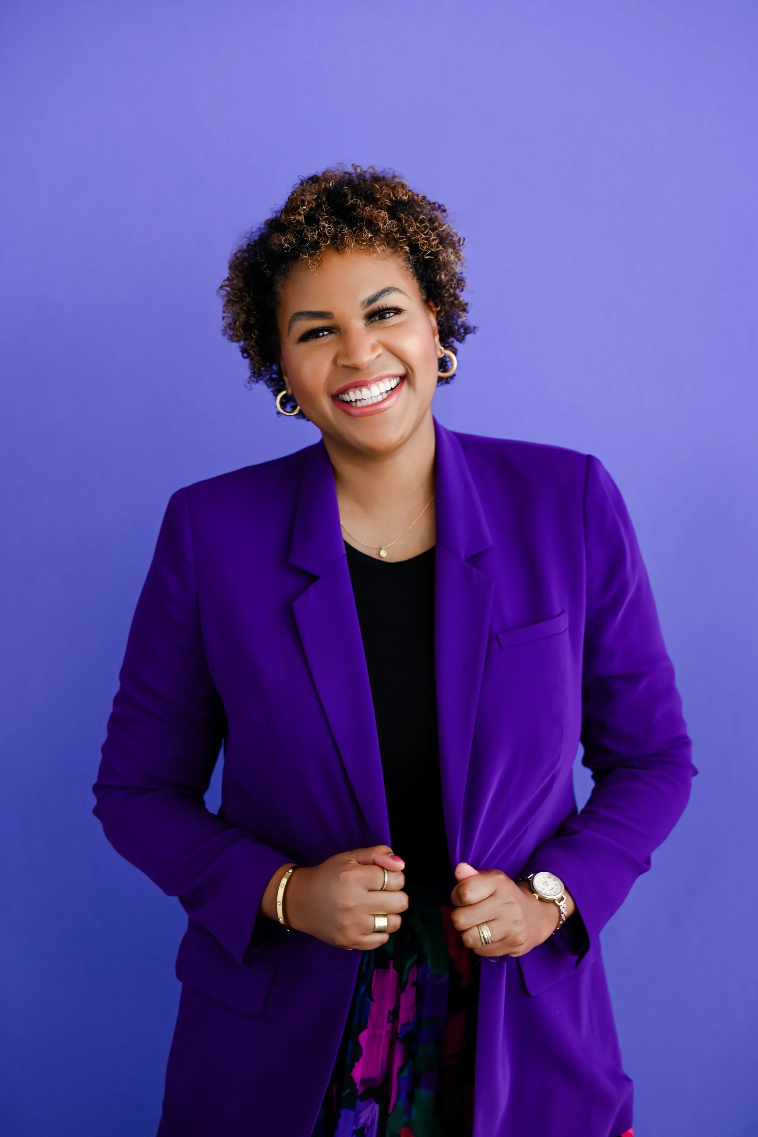 Dr. Amber Benton is smiling and wearing a purple blazer