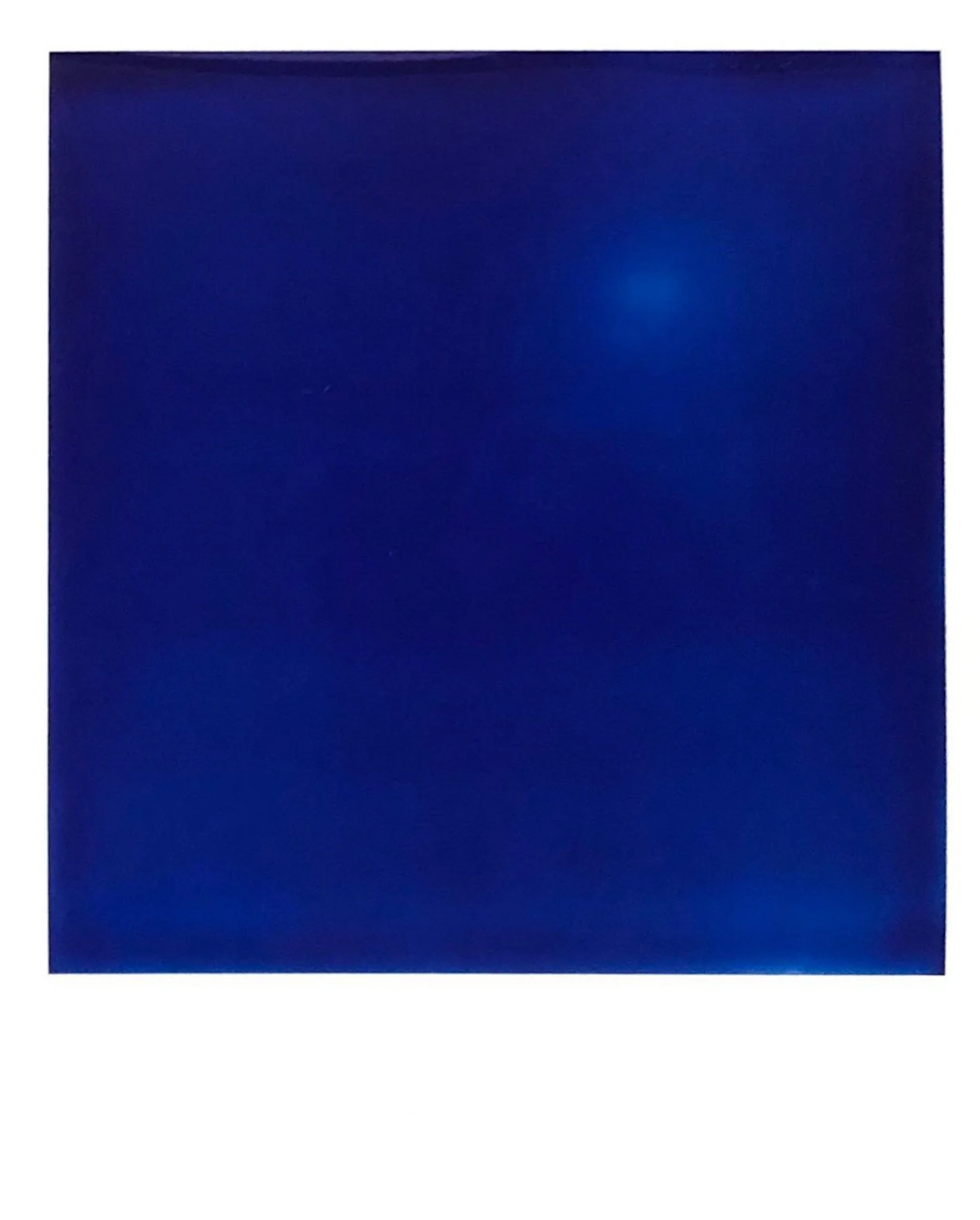 Un carré bleu foncé avec une tache lumineuse bleue en haut à droite.