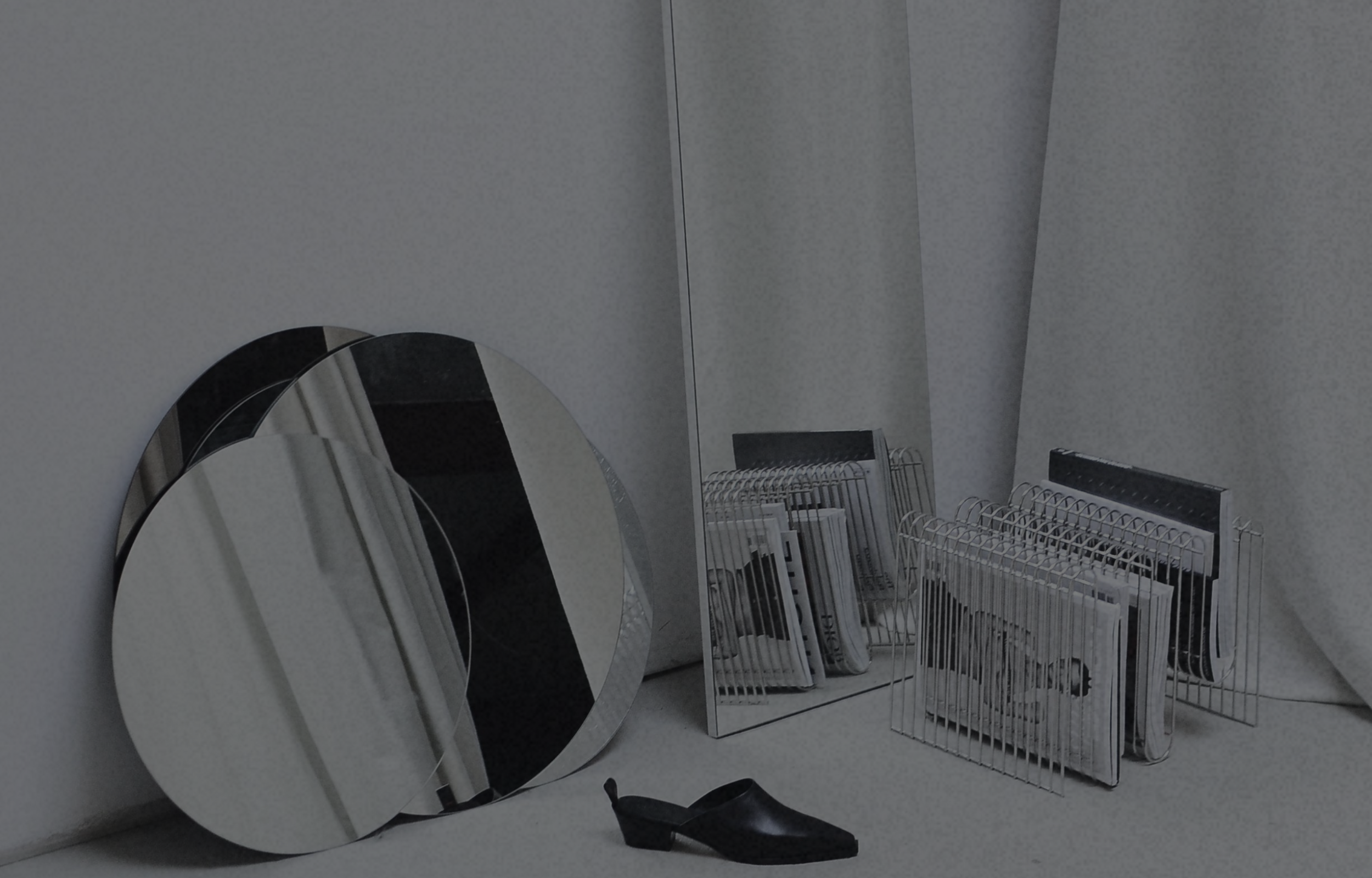 Minimal editorial studio with mirrors, fashion books, and modern styling representing creative strategy, brand development, and operational excellence in the fashion industry.