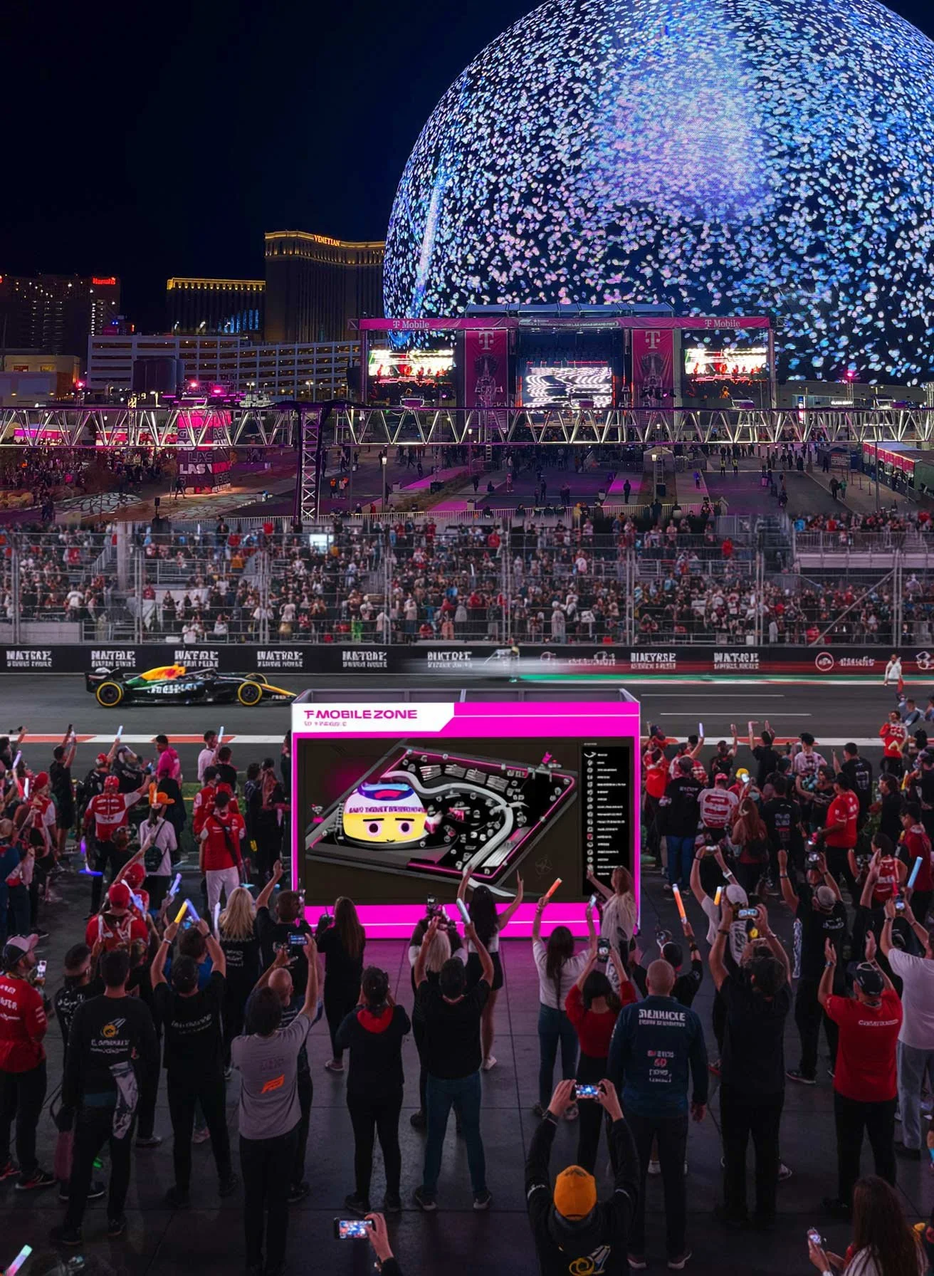 Night scene of a Formula 1 race event with a crowd watching, a track with a car passing, a large digital screen showing a cartoon race car, and a vibrant light display in the background.