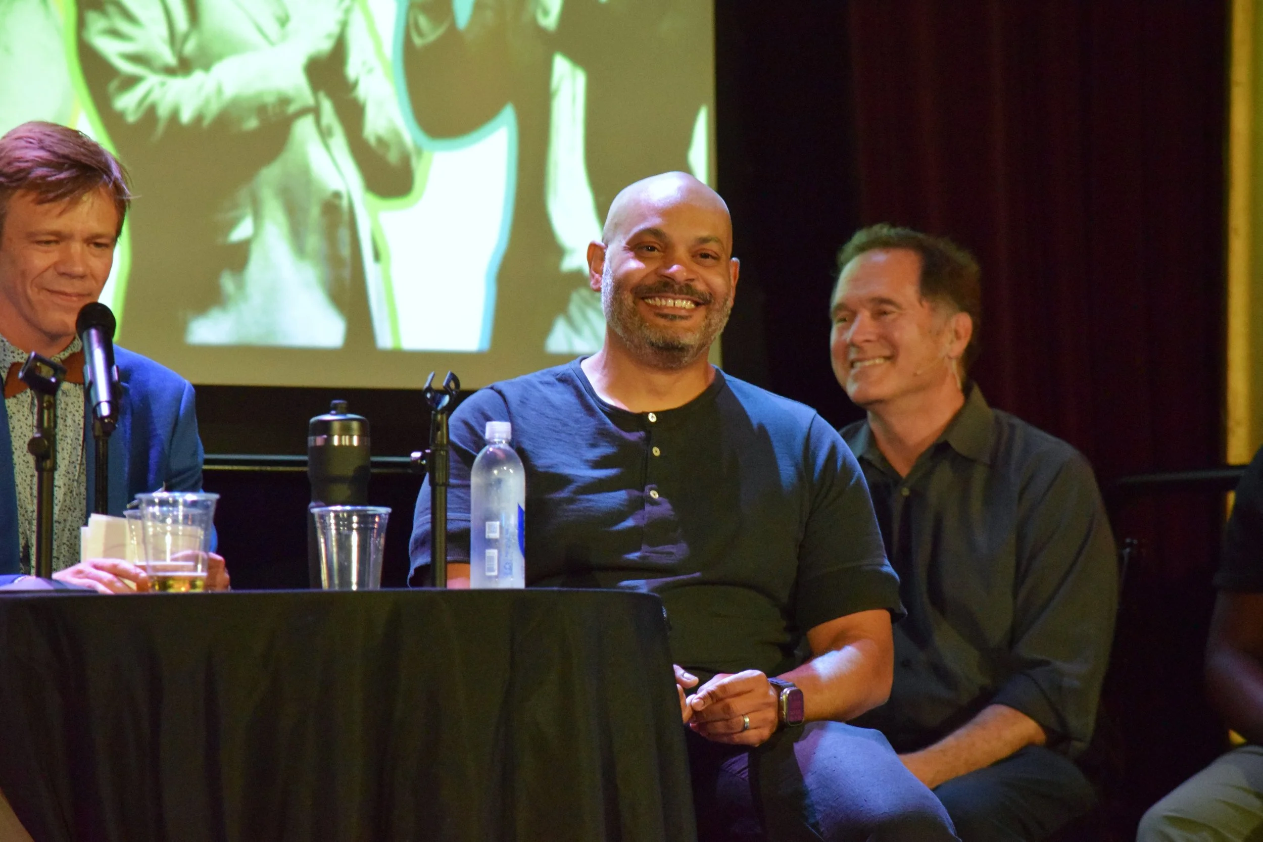  Council President Elliott Payne (middle) laughs onstage during  The Theater of Public Policy . 