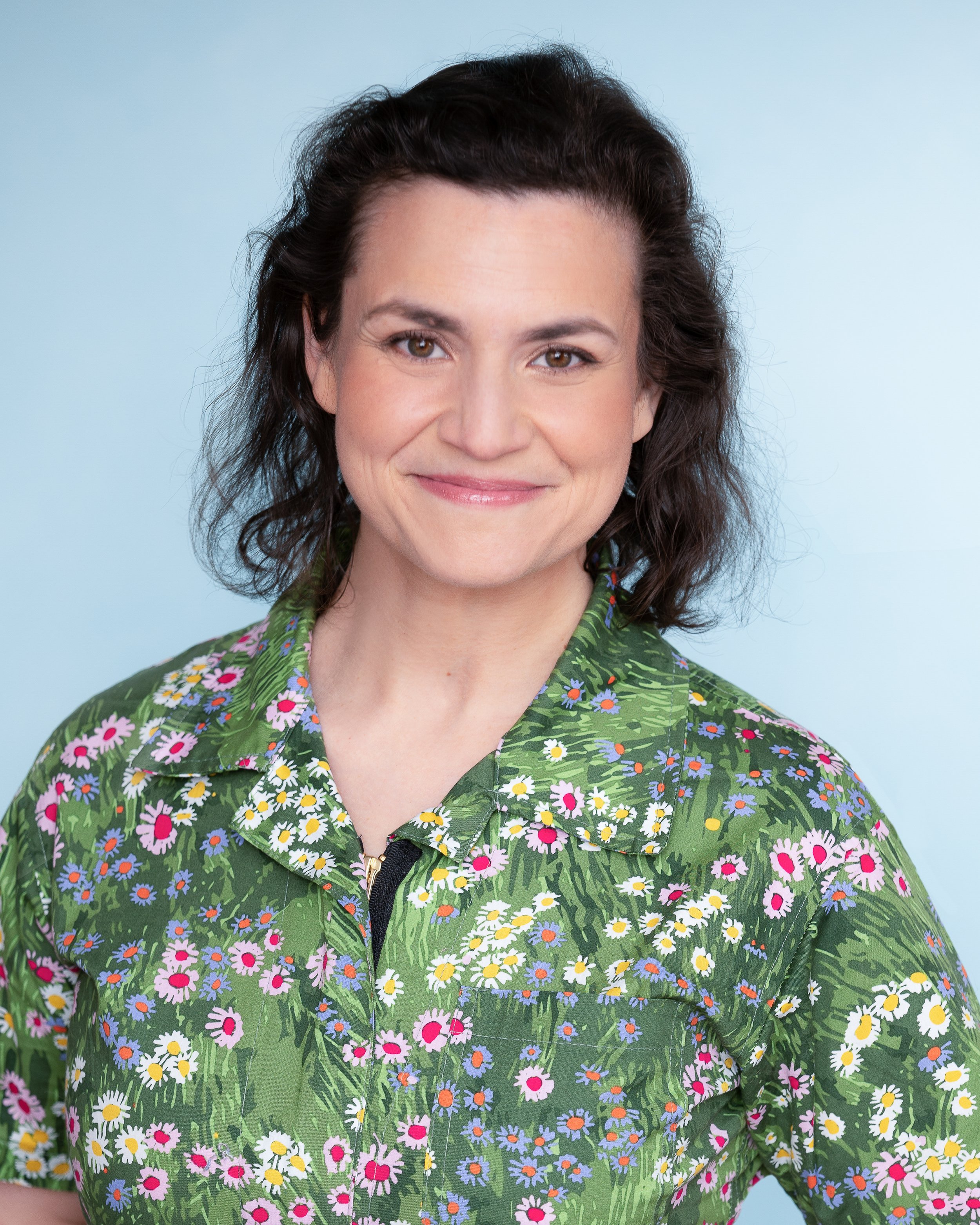 Actor Taj Ruler in a floral print shirt on a light blue background
