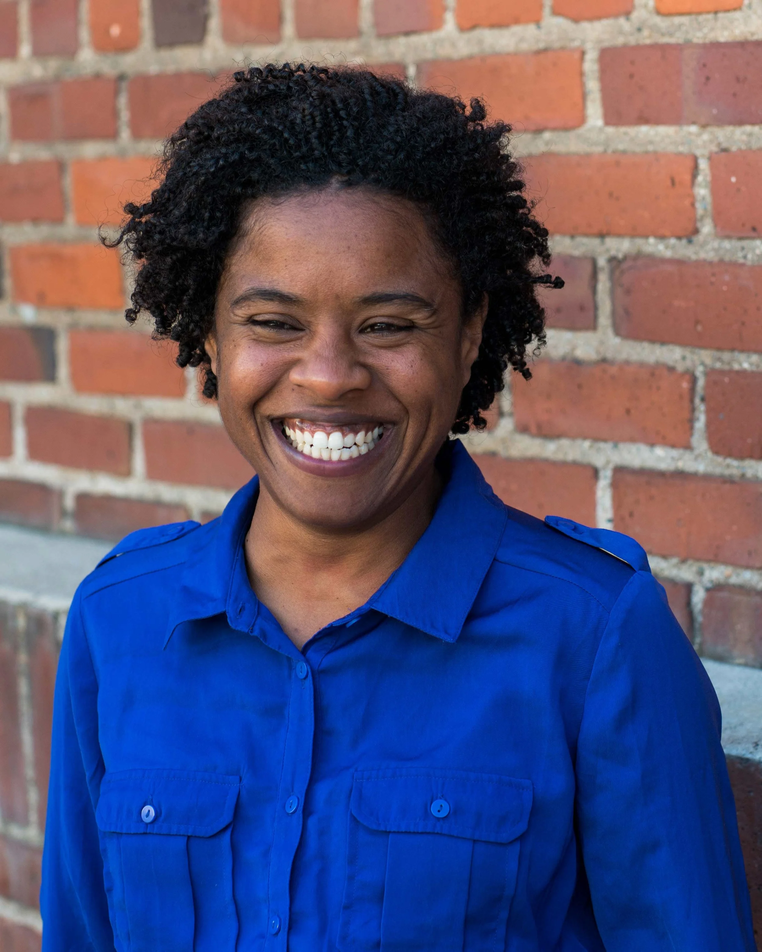 Actor Alexis Camille in front of a brick wall