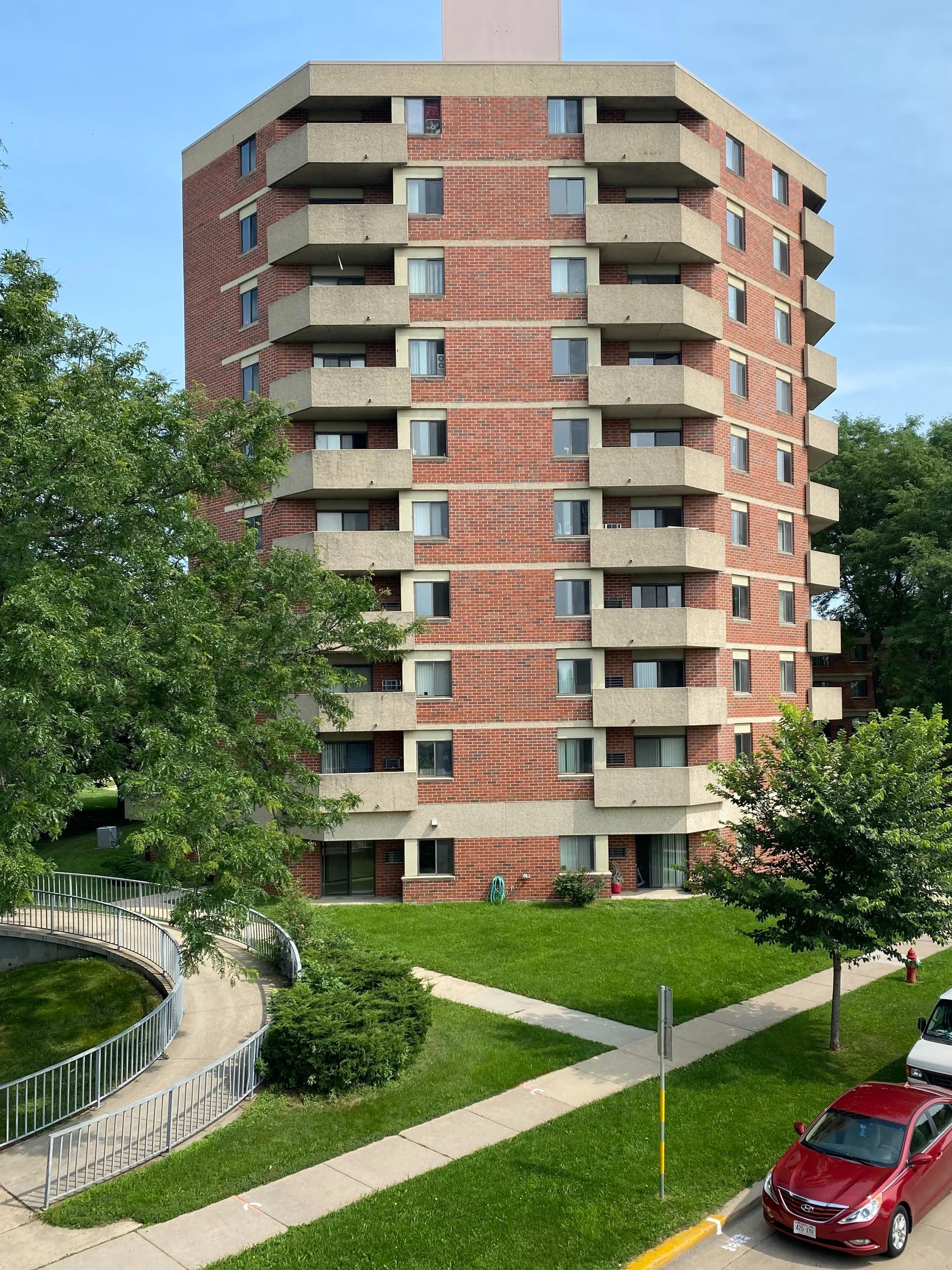 Brick apartment building with cement balconies.