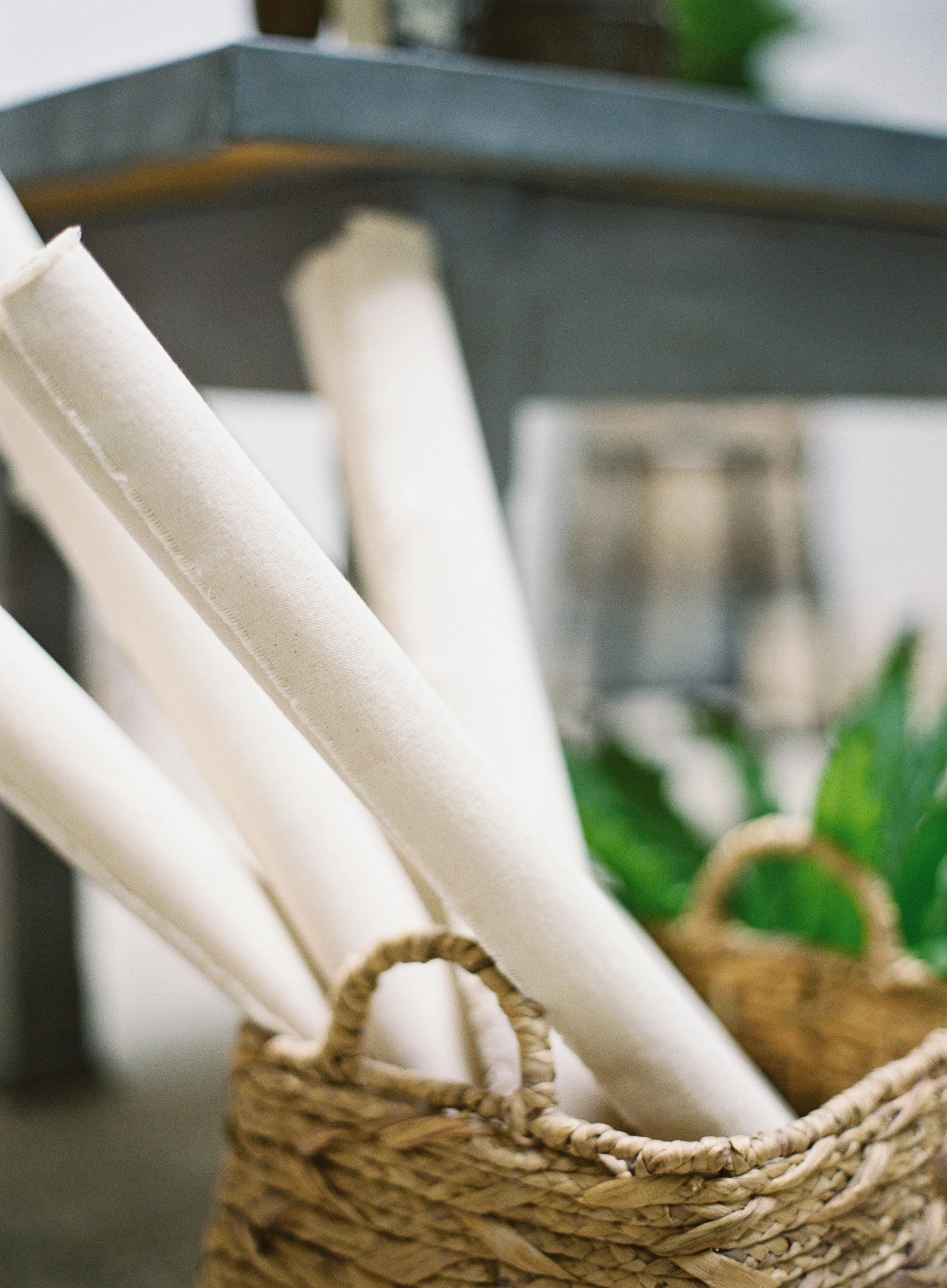 Rolled photography backdrops stored vertically in wicker baskets for organized studio backdrop storage