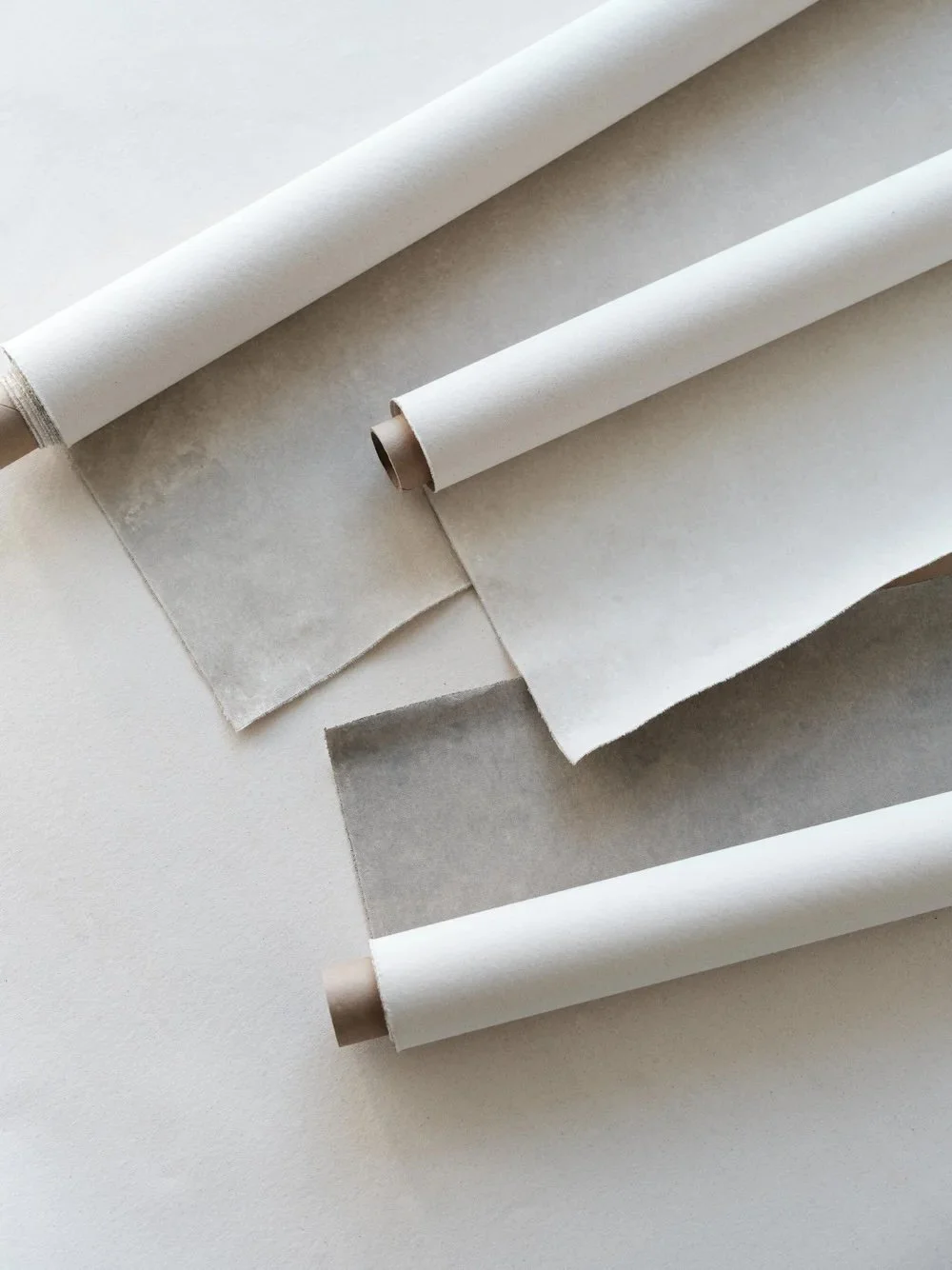 Chasing Stone hand-painted canvas backdrops rolled on cardboard cores in Limestone, Bentonite, and Silt colorways