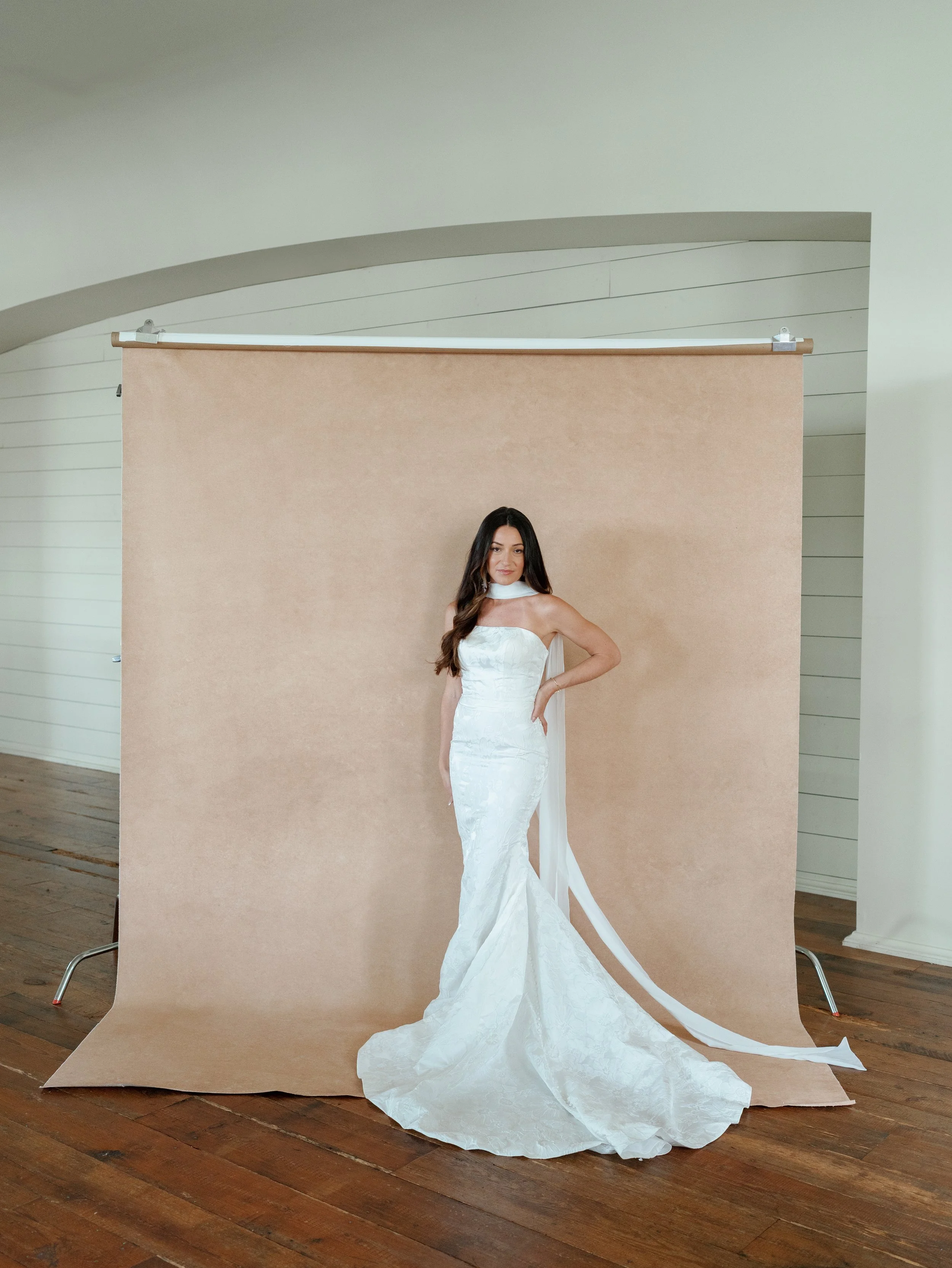 Bride posing in front of a portable photography backdrop during a wedding portrait session
