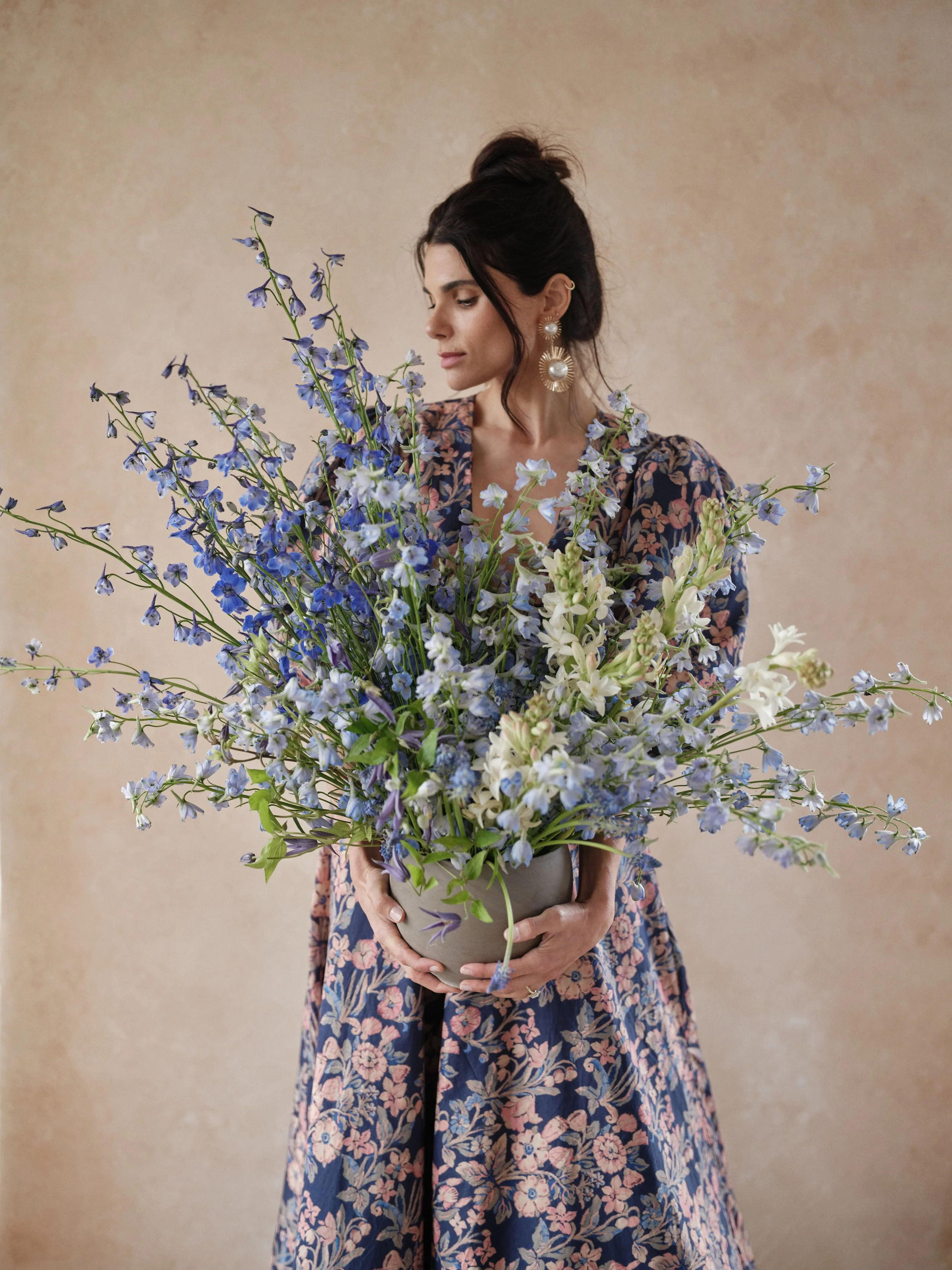 portrait photography on terracotta backdrop showing complementary color harmony with cool blue flowers and warm background demonstrating color theory for photographers