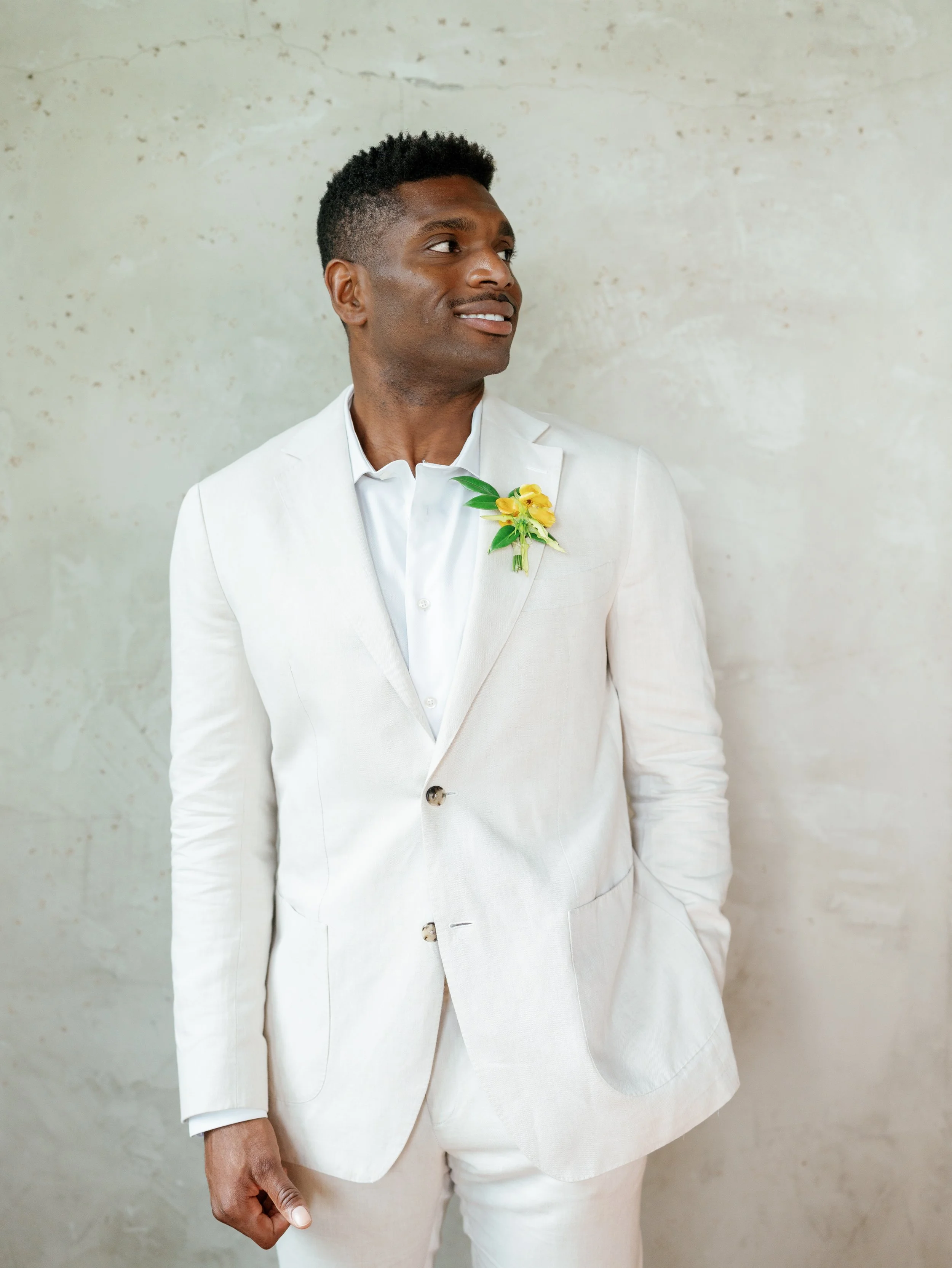 Groom portrait photographed against a warm neutral hand-painted photography backdrop in a studio