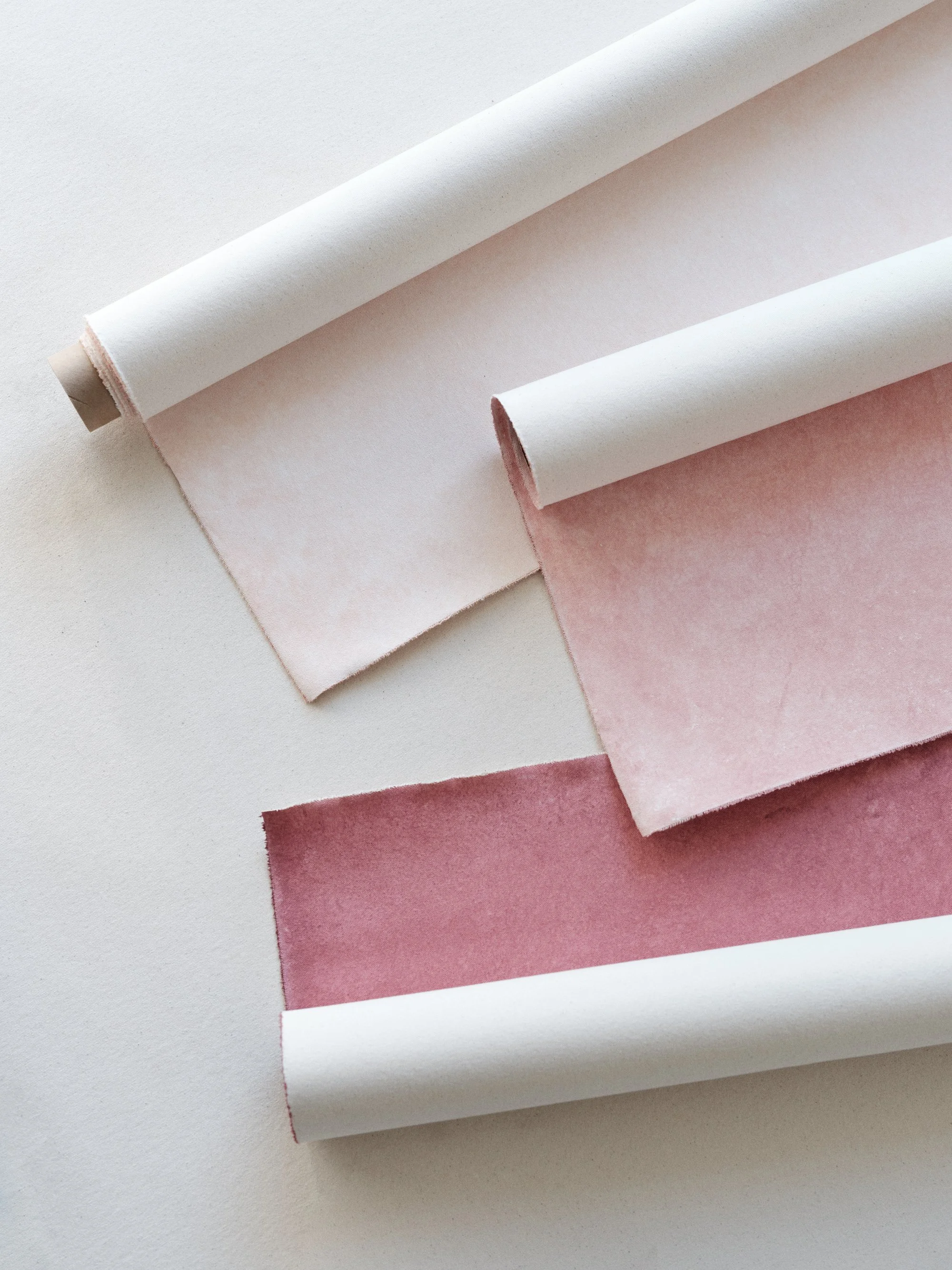 Three Chasing Stone pink and mauve hand-painted canvas backdrops showing Rose Quartz, Rhodonite, and Hematite colorways