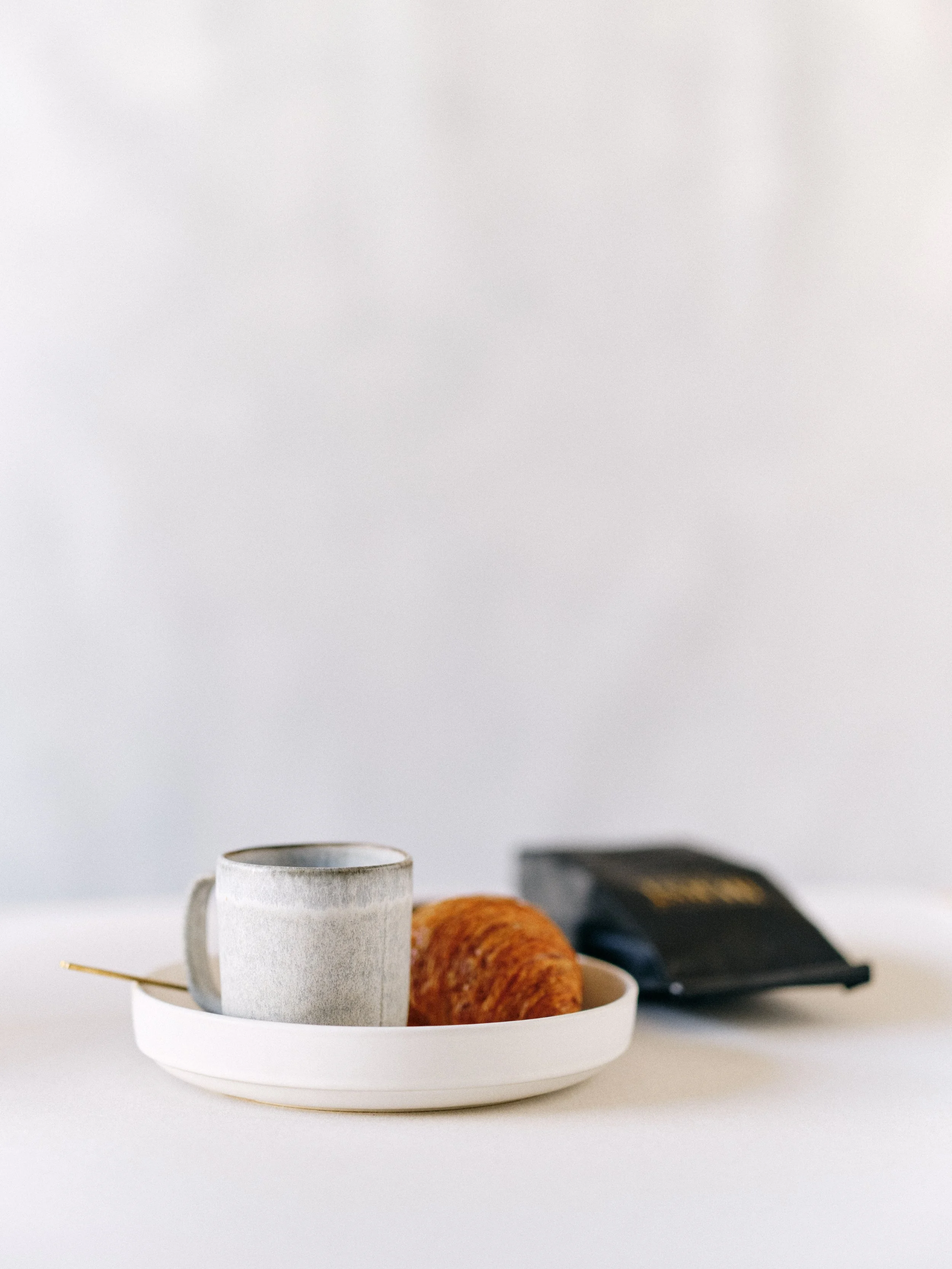 Minimal flat lay demonstrating the 60/40 negative space ratio with three styled objects on a clean white Chasing Stone photography surface