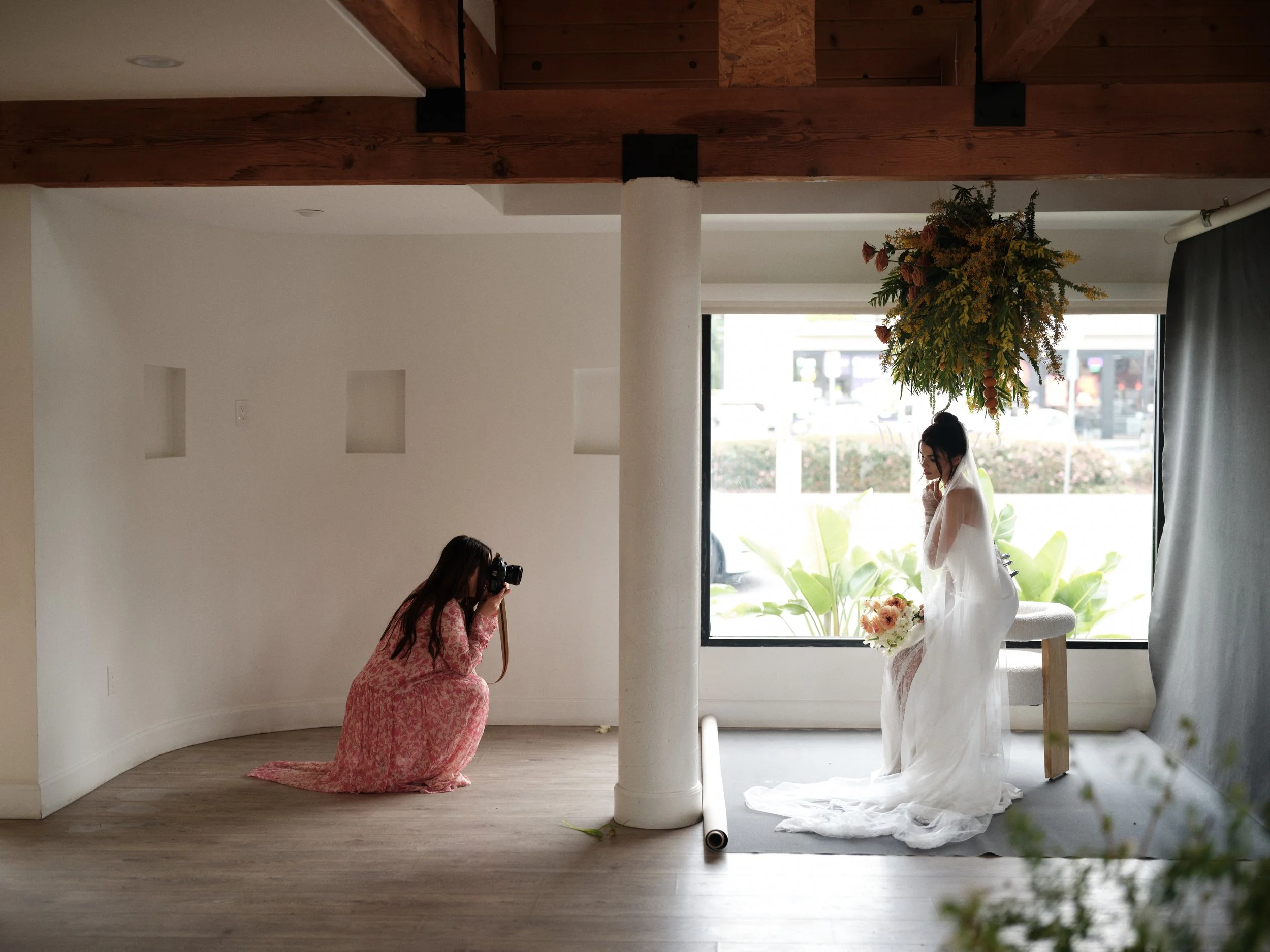 natural window light bridal photography setup showing photographer shooting bride positioned by window for professional wedding portraits