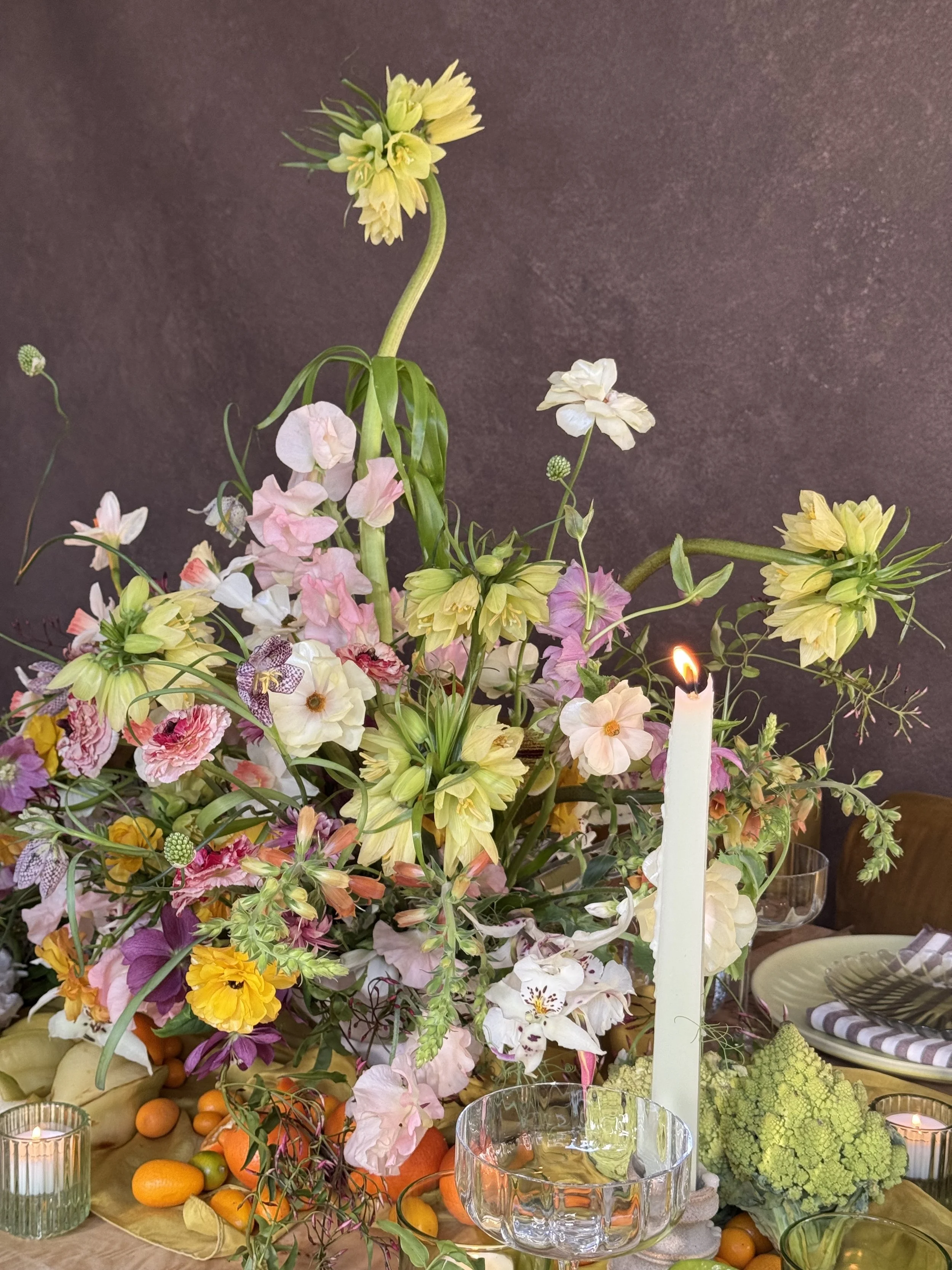 Floral arrangement styled on a warm-toned hand-painted canvas backdrop from Chasing Stone