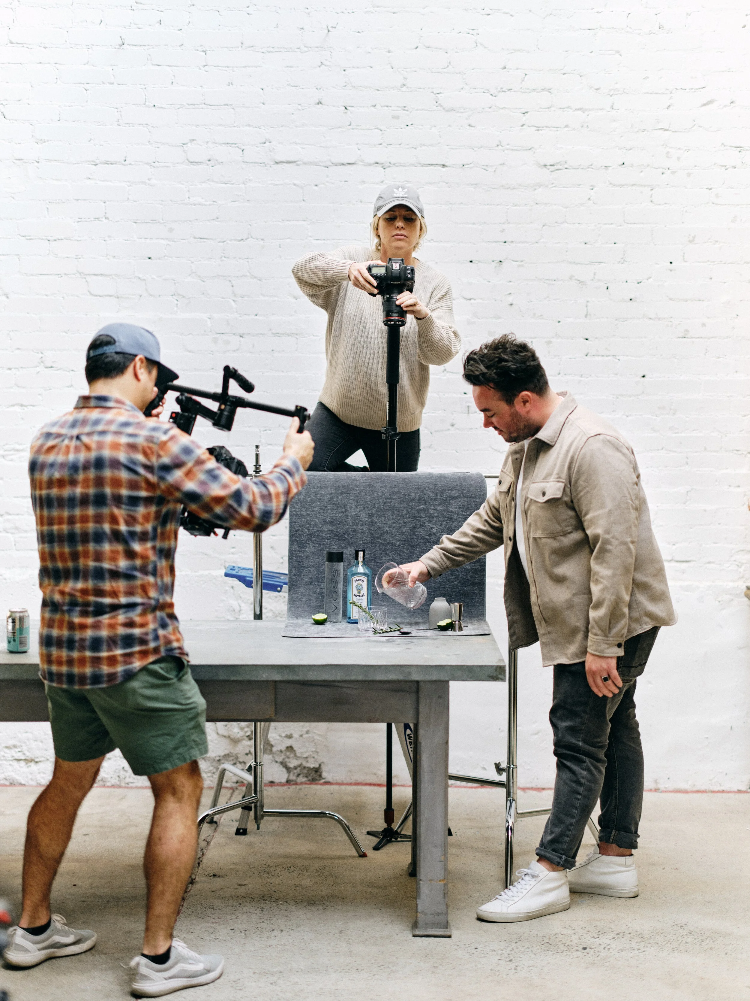 Professional flat lay photography team demonstrating proper overhead camera positioning and collaborative styling process